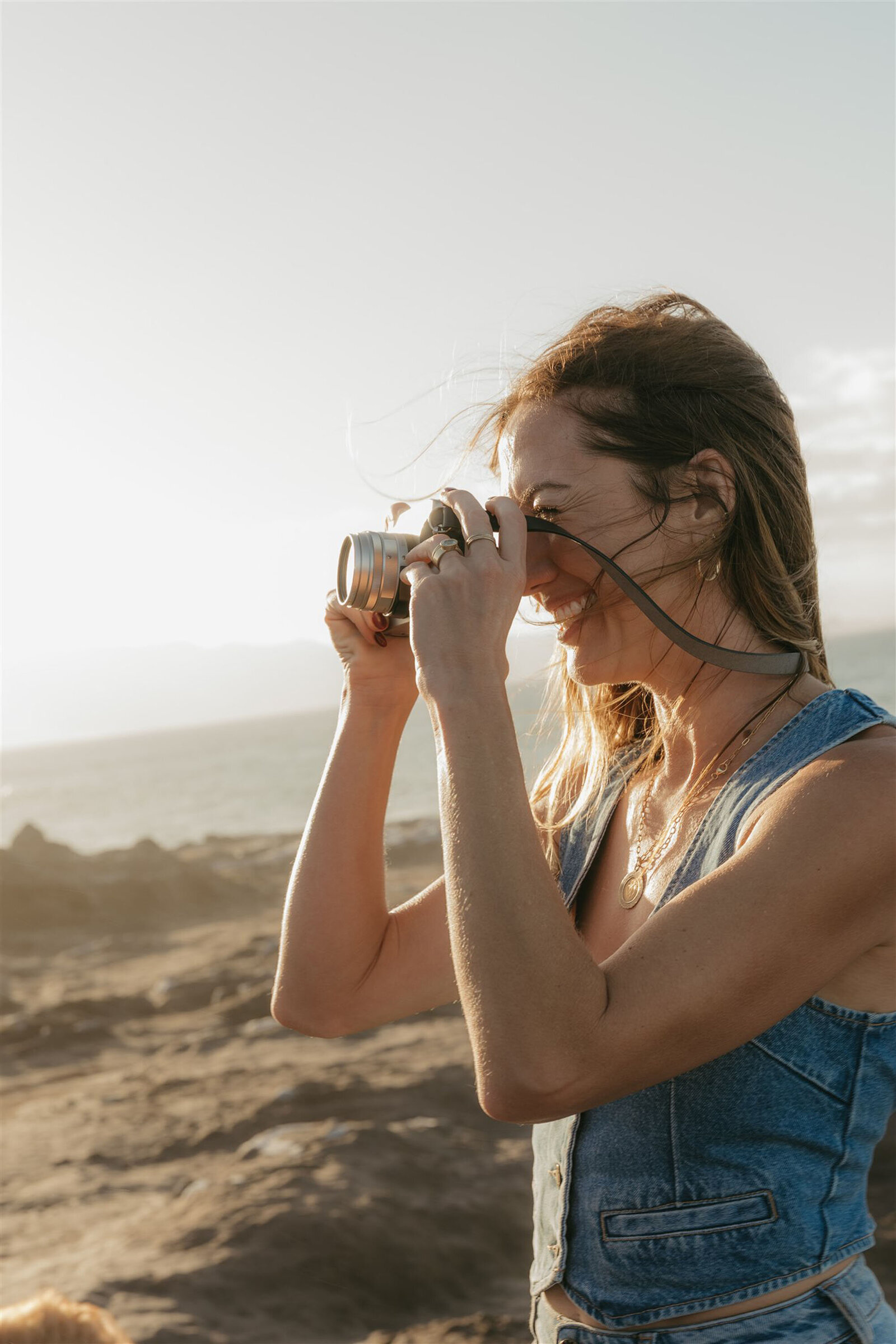 Together on a Maui cliffside at sunset, wearing denim and neutral outfits during an editorial family photography session.