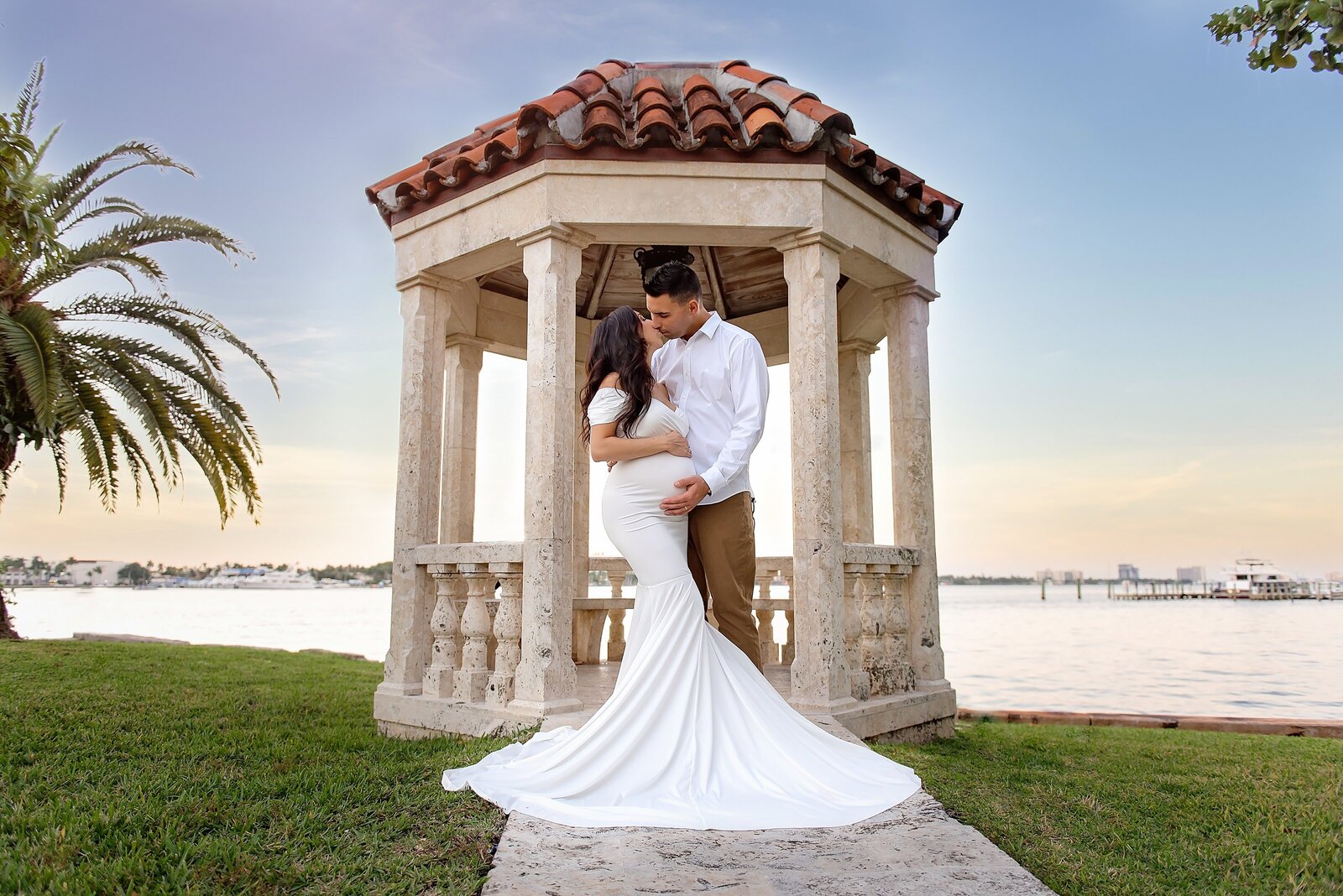 Maternity photographer captures couple at sunset in gazebo at Bradley Park in Palm Beach, FL.