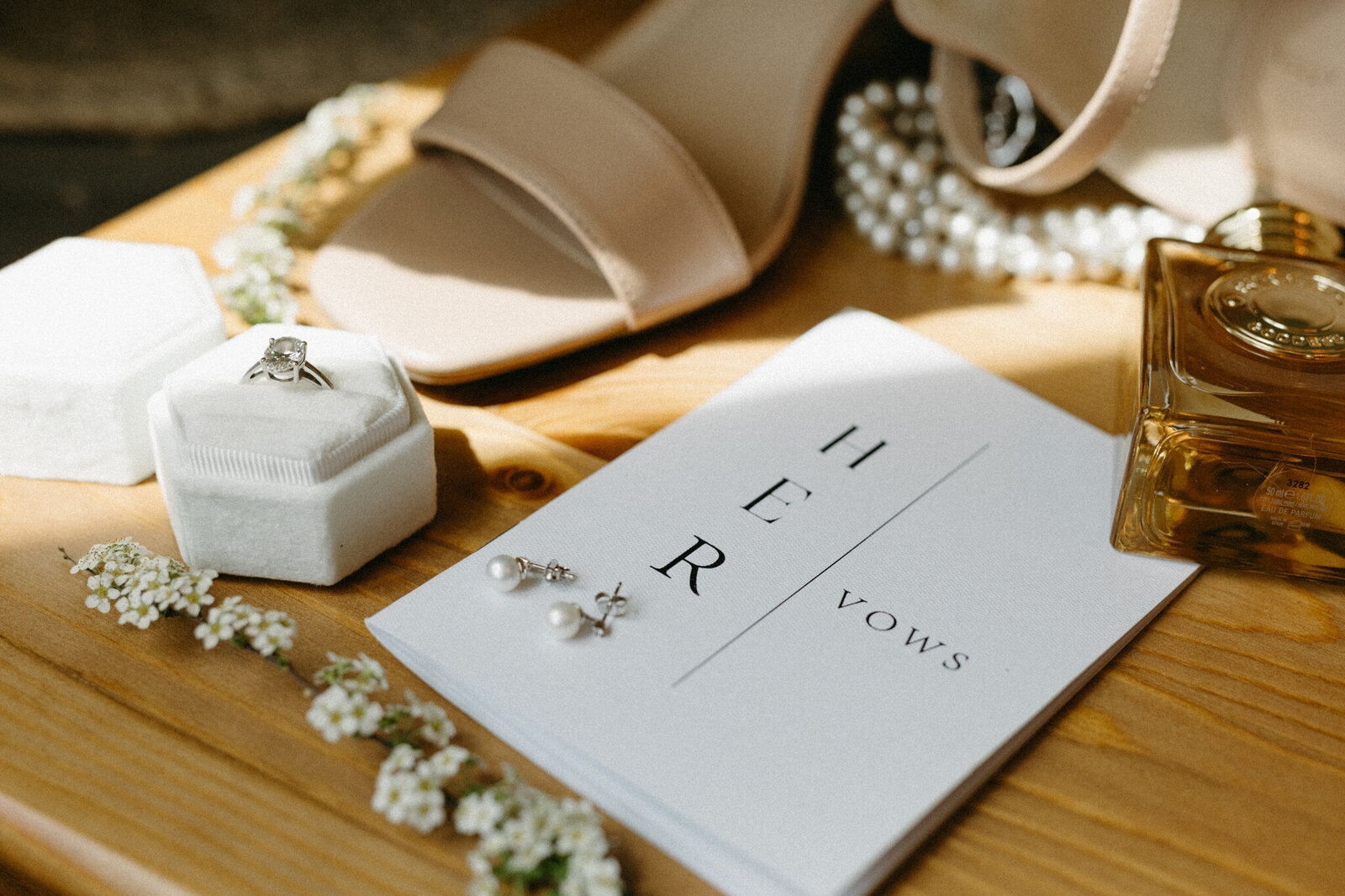 detail photo of vow books, shoes and ring at fernie wedding