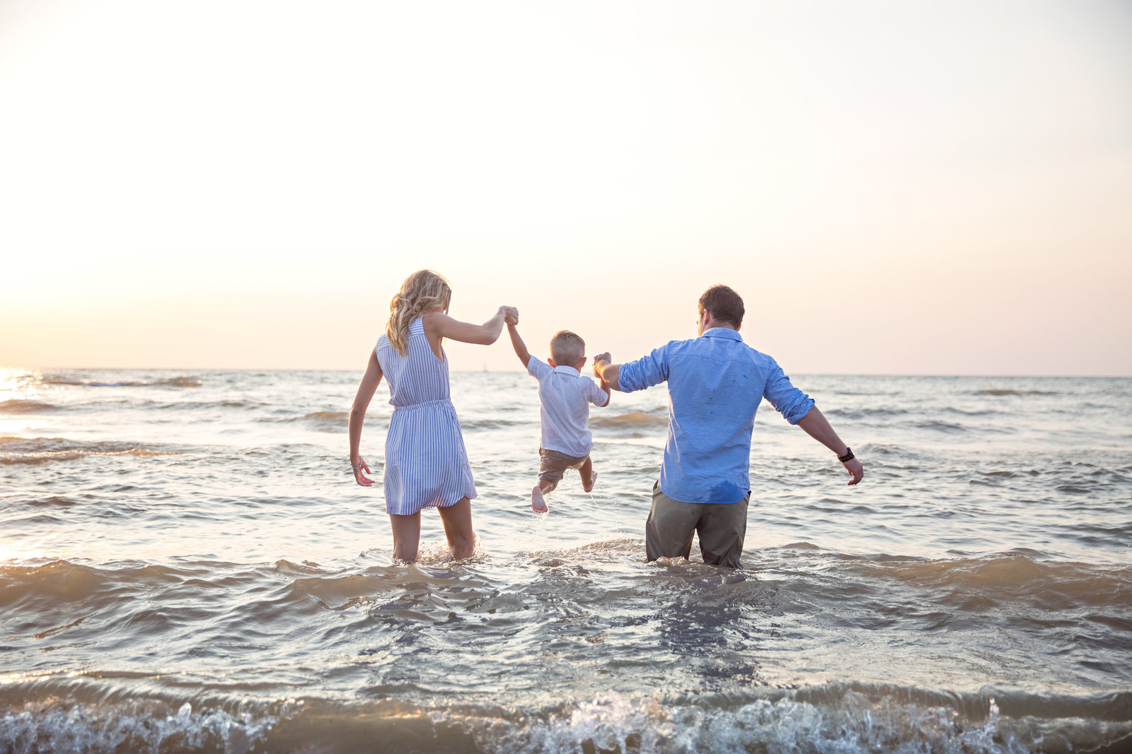 family walking into the water at the beach