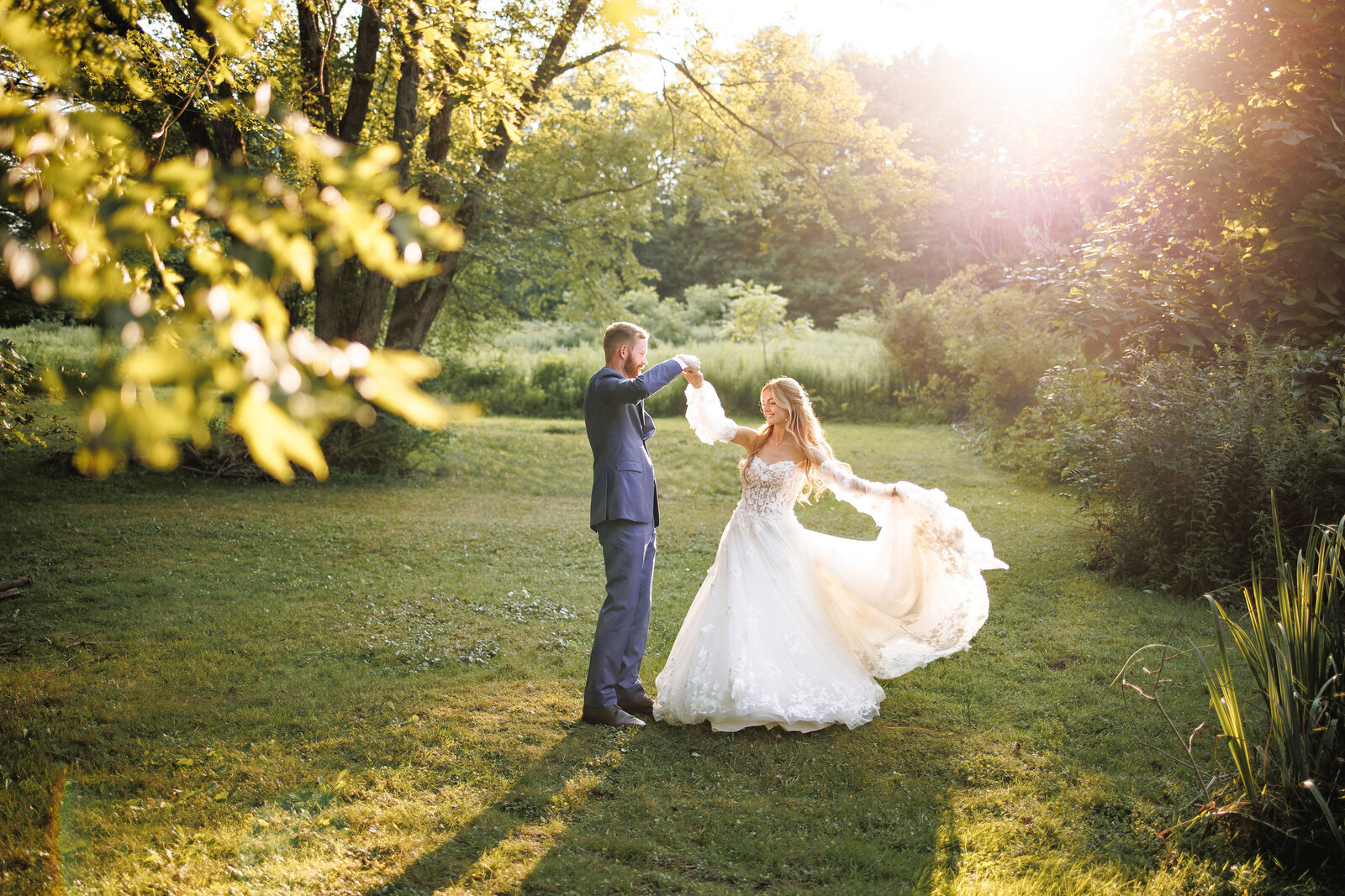 Newly wed couple dancing together as beautiful golden sunlight shines through the trees