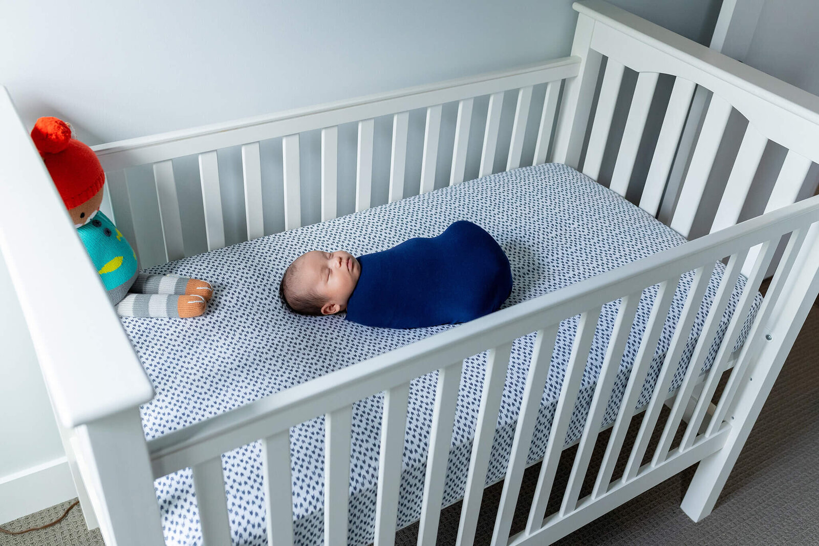 A newborn baby boy laying in his crib for his Northern Virginia newborn photos.
