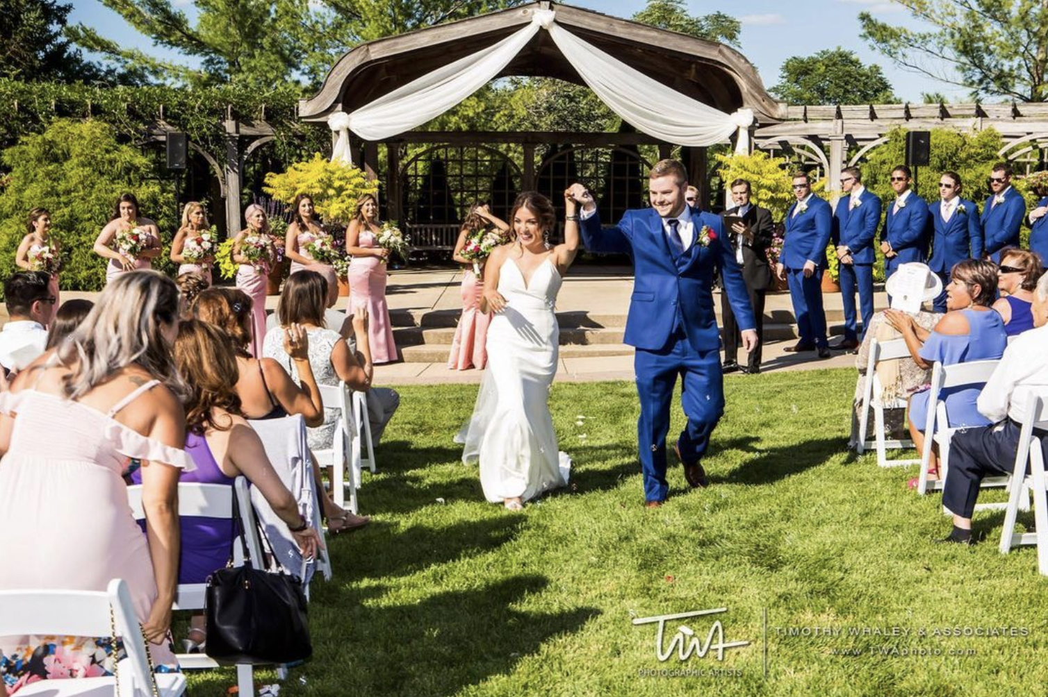 Bride and groom walk triumphantly back down the aisle after getting married