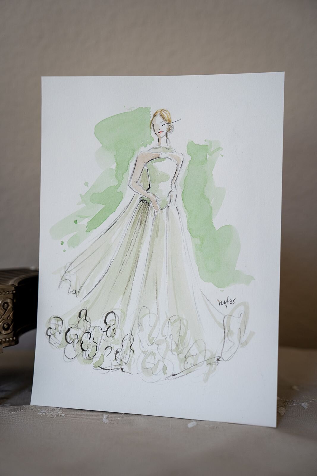 Watercolor fashion illustration of a wedding guest wearing a green dress.