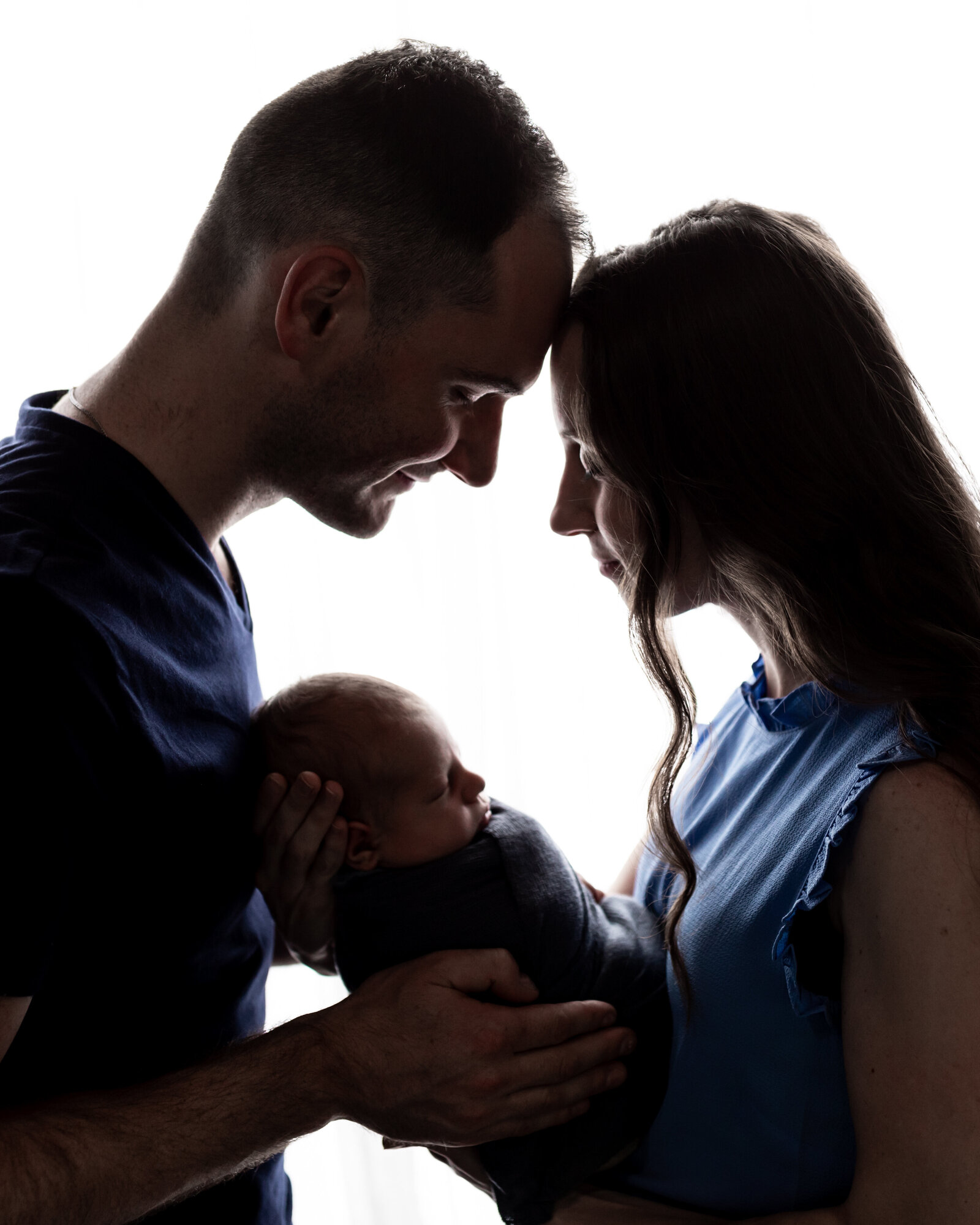 mom and dad holding newborn son for studio portraits