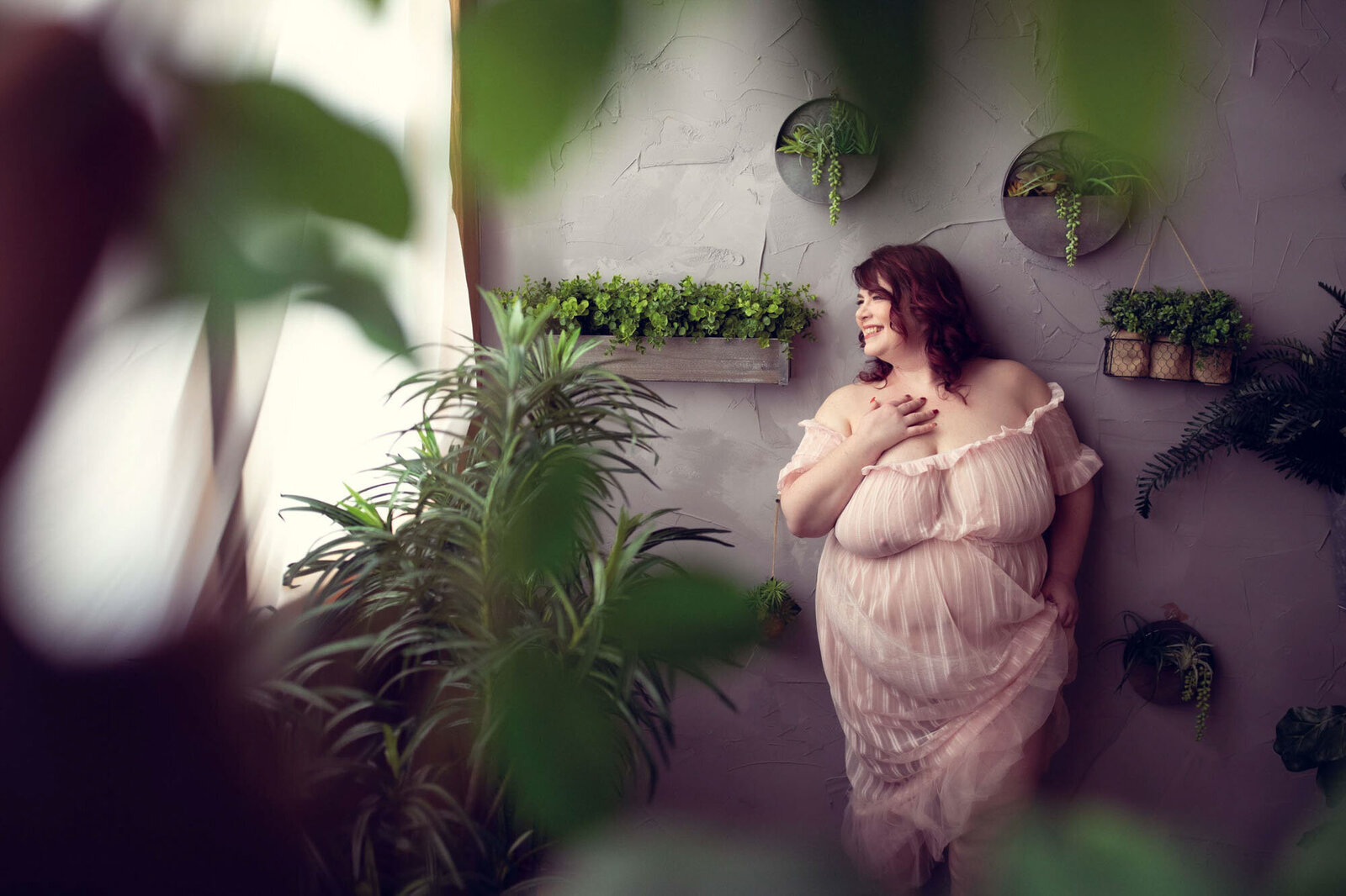 woman leaning on the wall with plant around her