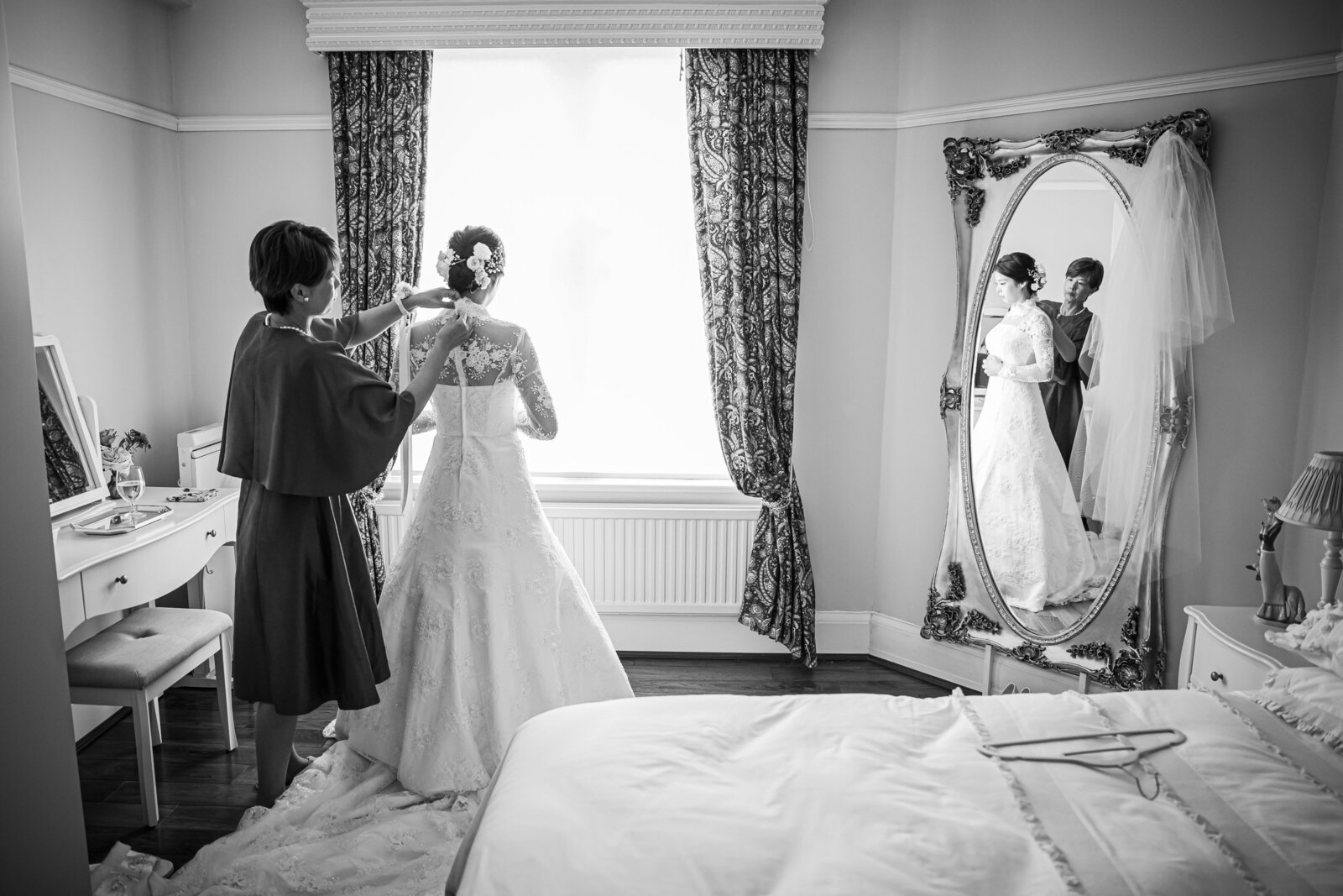 The mother of the Bride helping her daughter get ready for her wedding