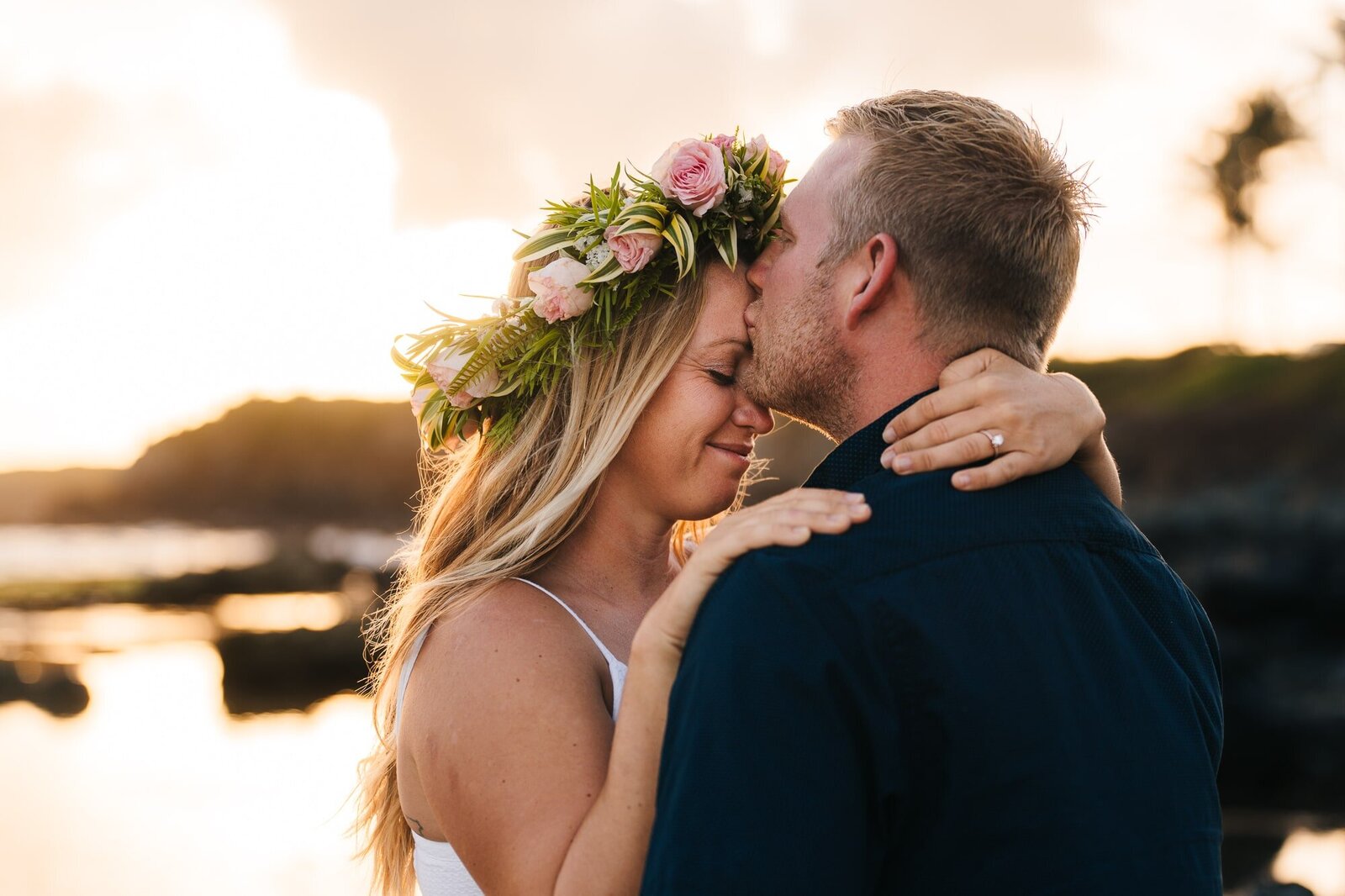 Couple sharing an intimate moment groom kissing her bride on the forehead during  their elopement in Maui.