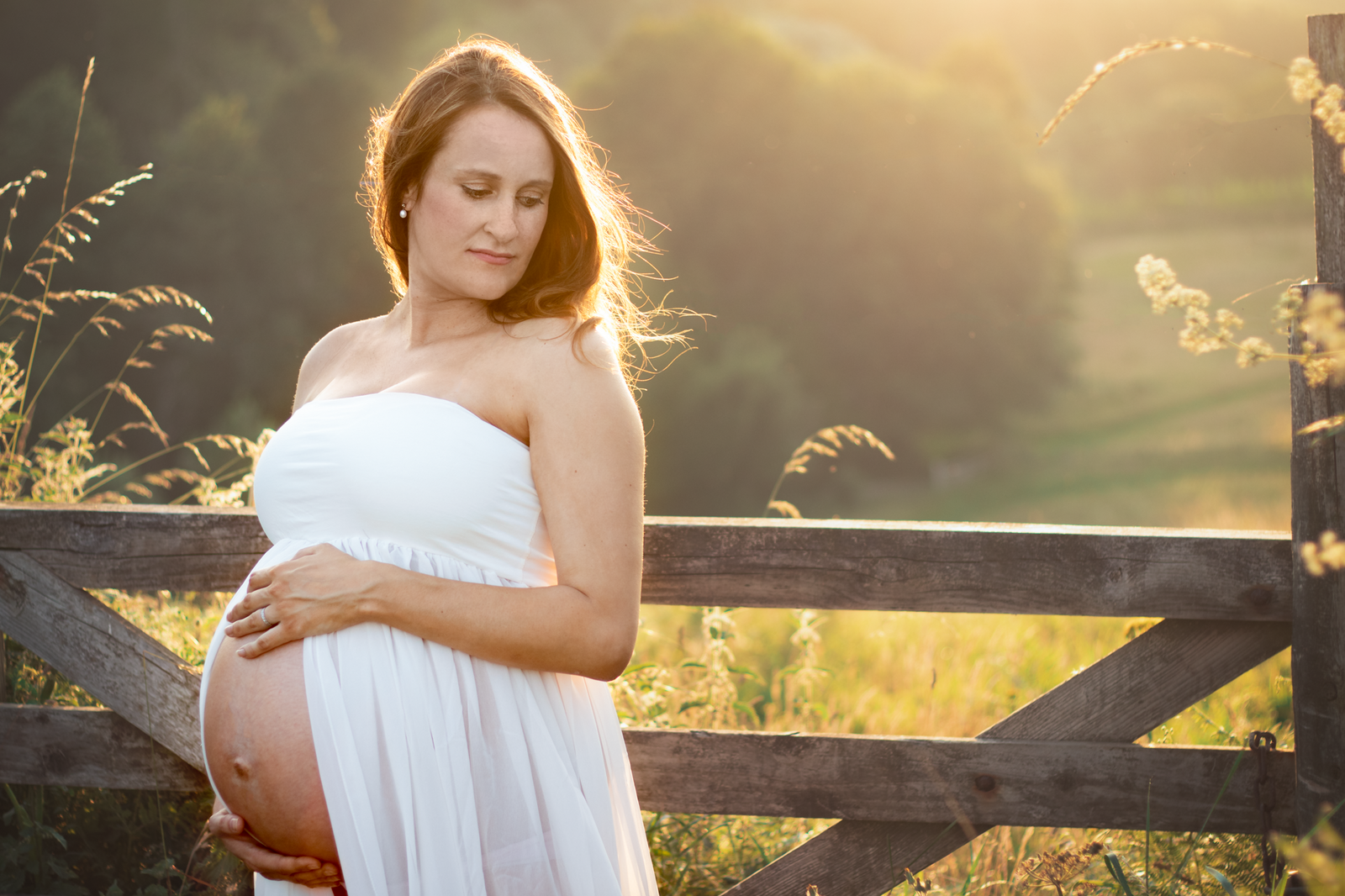Pregnant lady stand in golden hour light for maternity photos