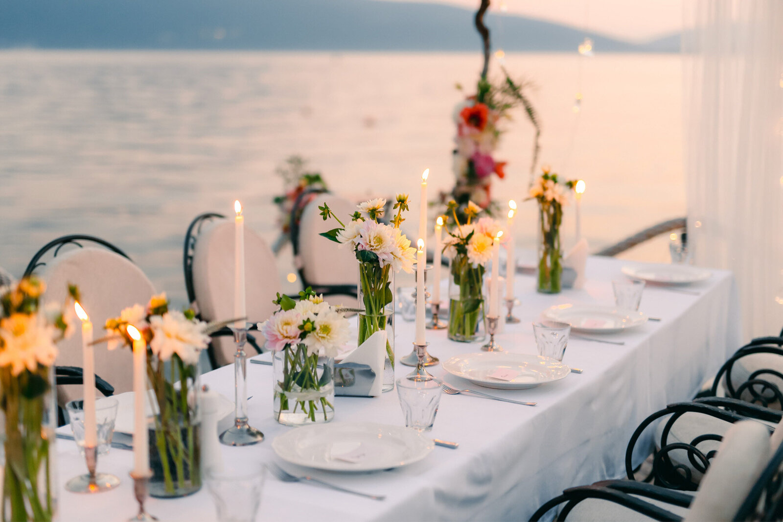 Seaside wedding reception table with florals and candle lighted centerpieces