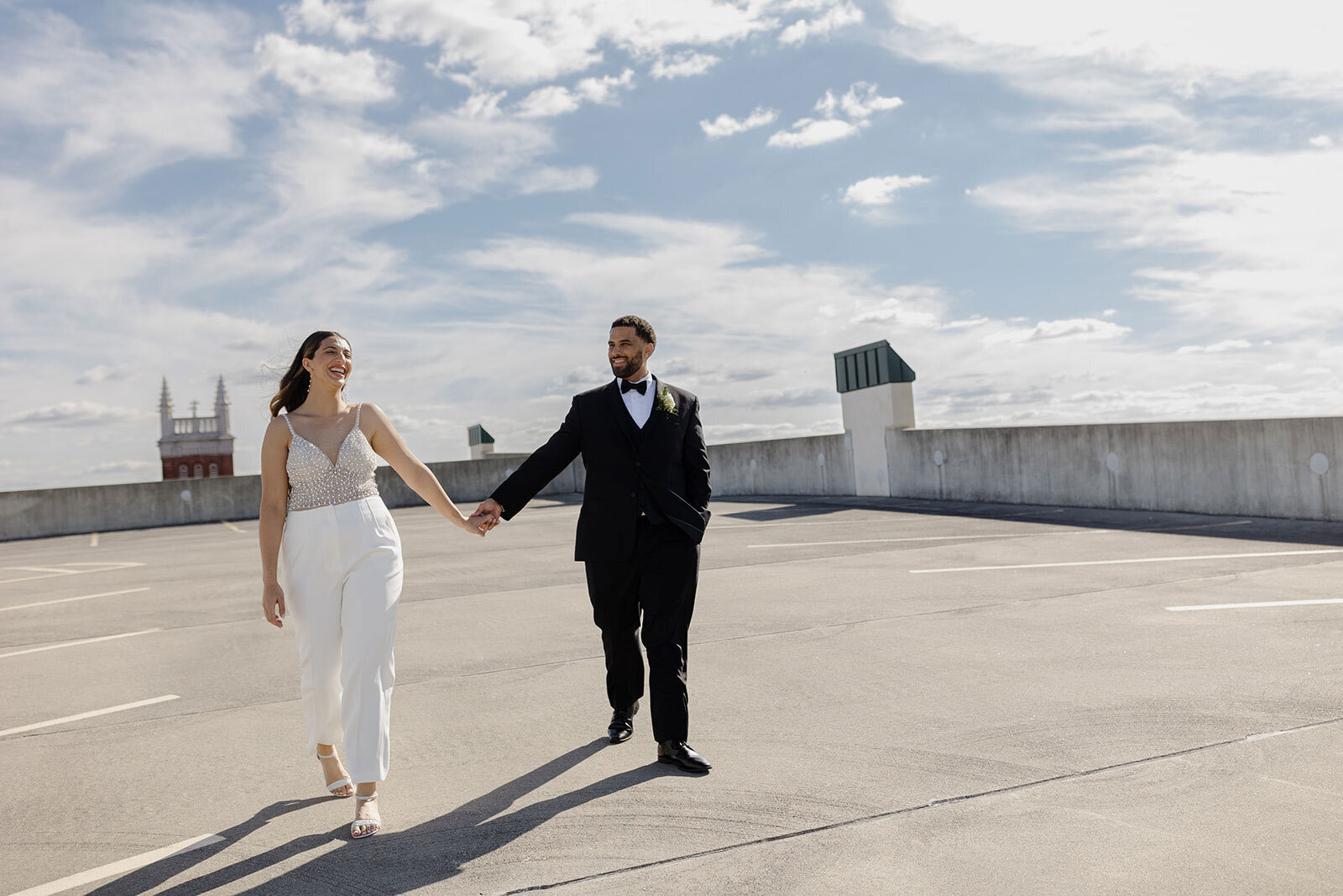 A couple walking hand in hand on the top of an empty parking garage during their elopement day in Lancaster City