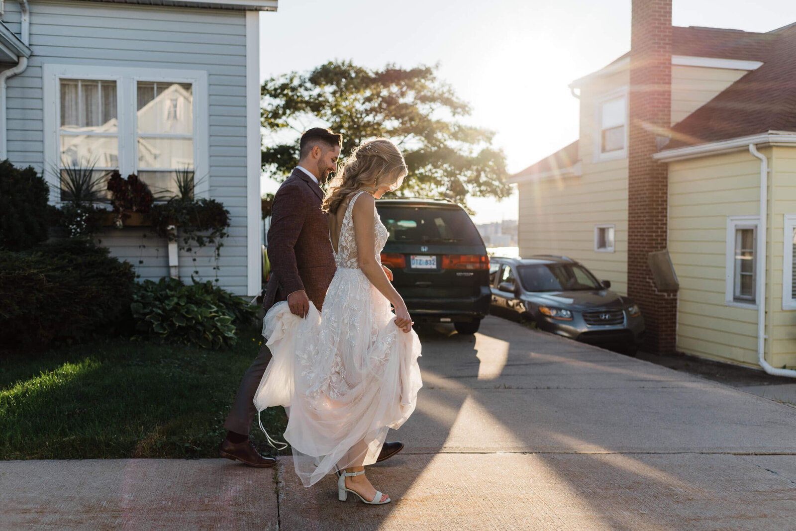 Couple dressed in wedding attire walking through Halifax neighbourhood.