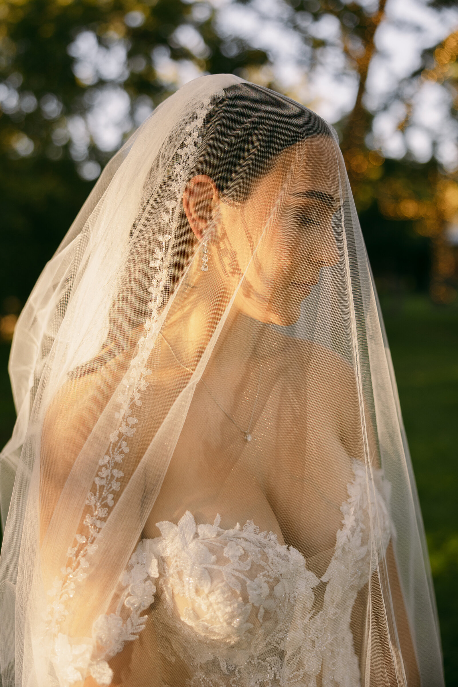 A bride looking off to the side with a veil over her head.