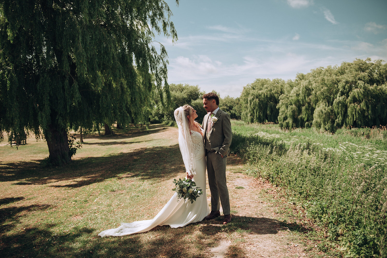 Bride and groom cuddling by the Quay in Sandwich during their wedding
