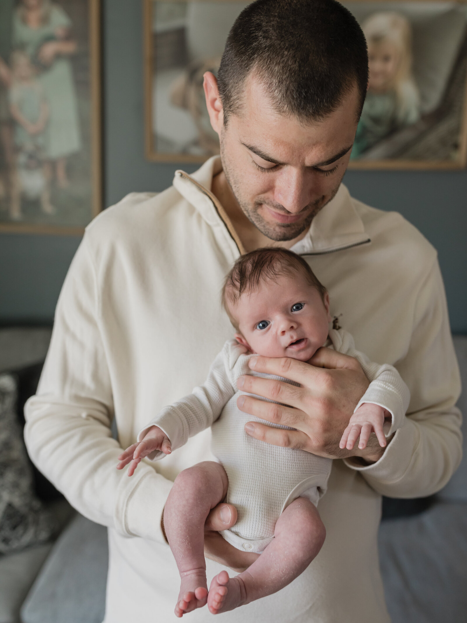 dad holding newborn baby boy for in home lifestyle session cleveland newborn photographer