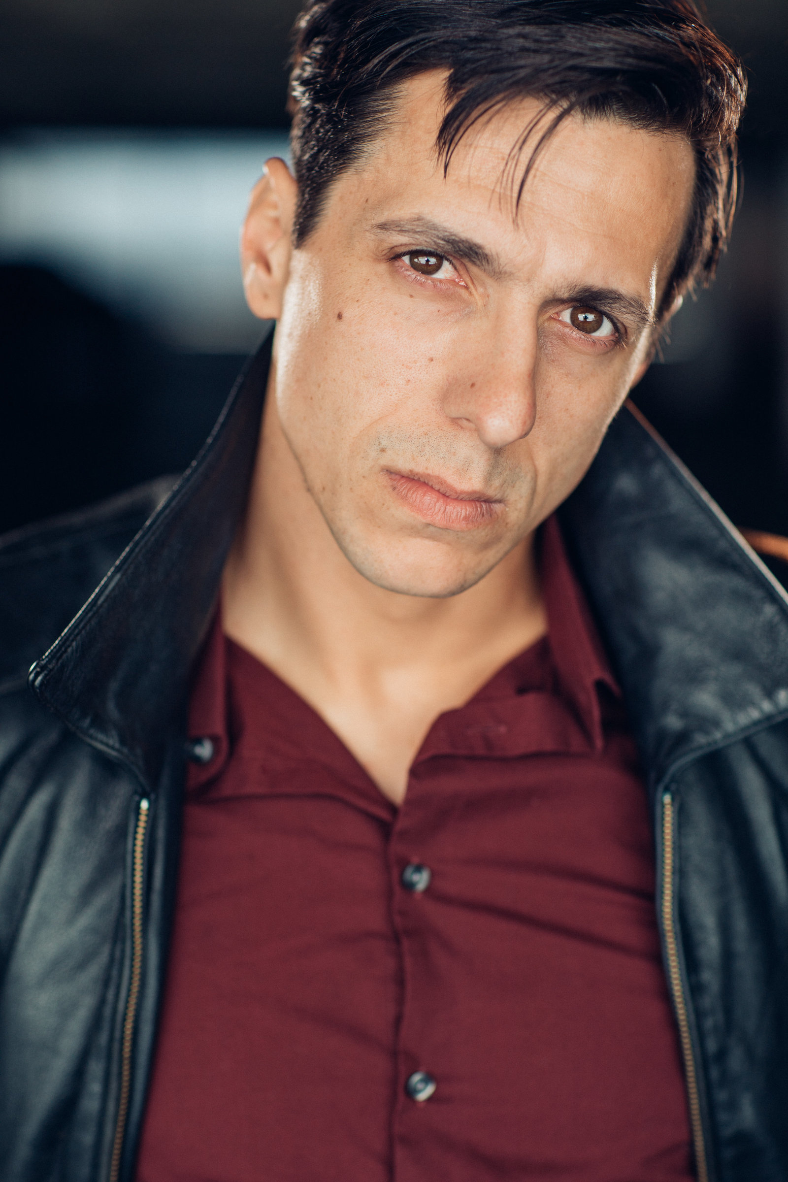 Headshot Photo Of Man In Black Leather Jacket And Maroon Polo