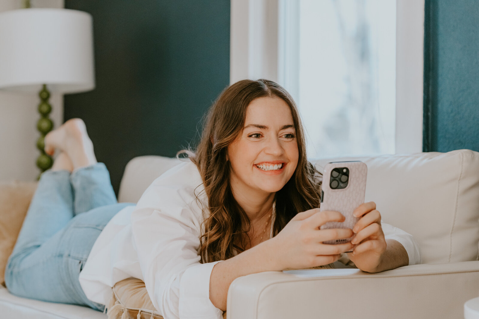 Rachel Haselwander, OBM and owner of Agera Business Services  sitting on a couch