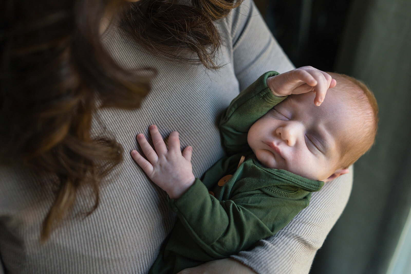 Newborn boy sleeps in his mom's arms