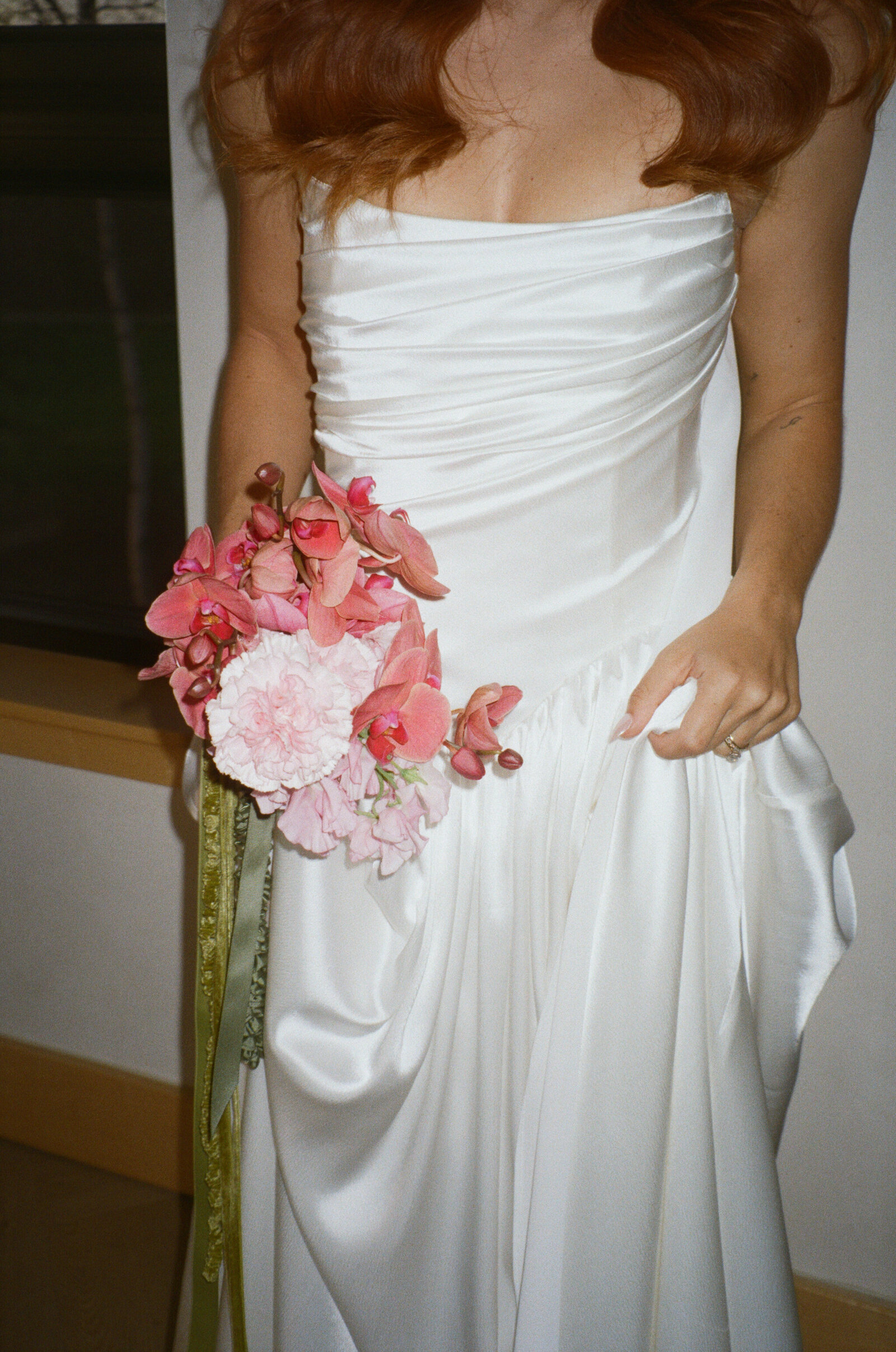 A bride holds on to her wedding dress and her bridal bouquet.