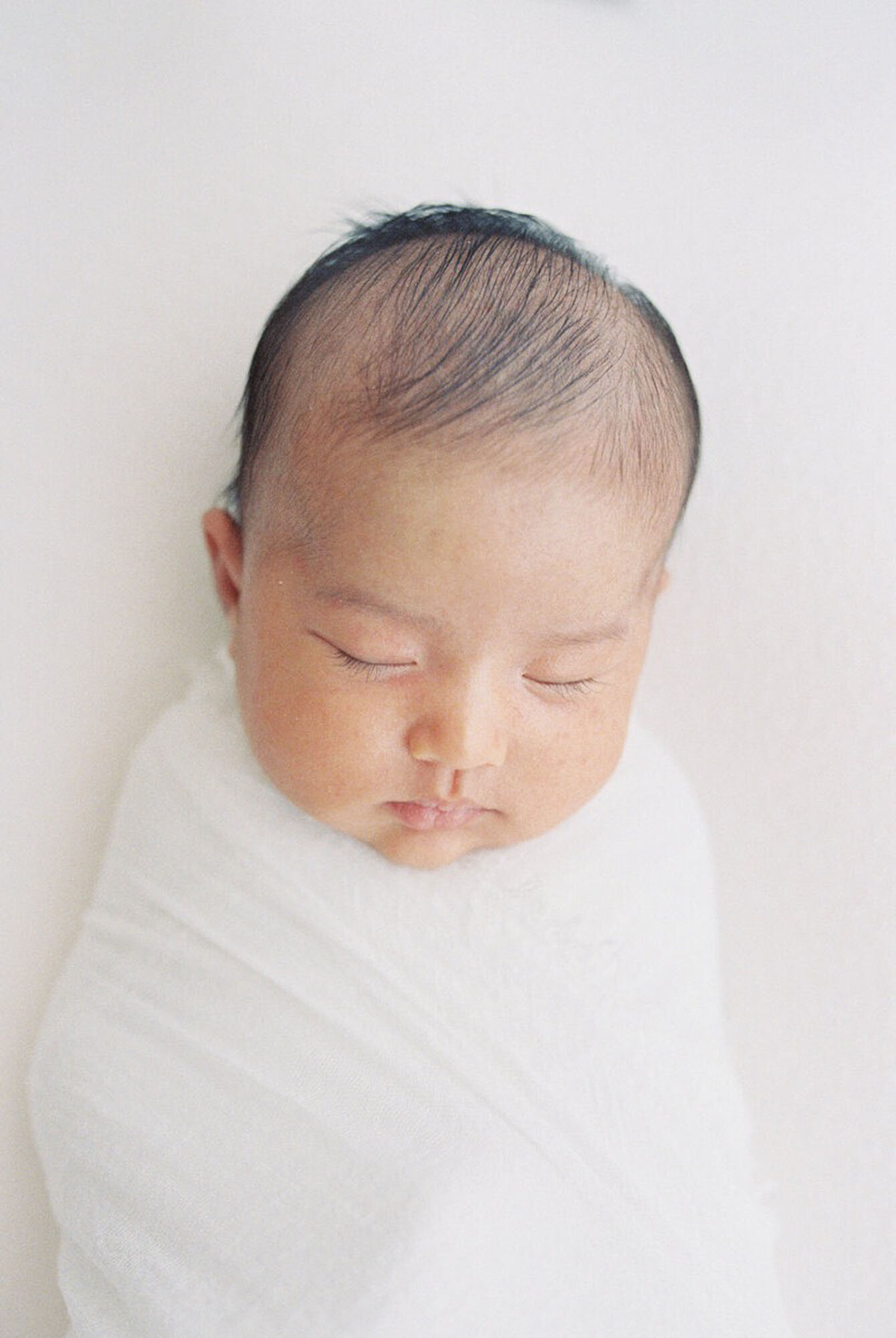 Swaddled baby posed on soft blanket during Bay Area newborn photography studio session.