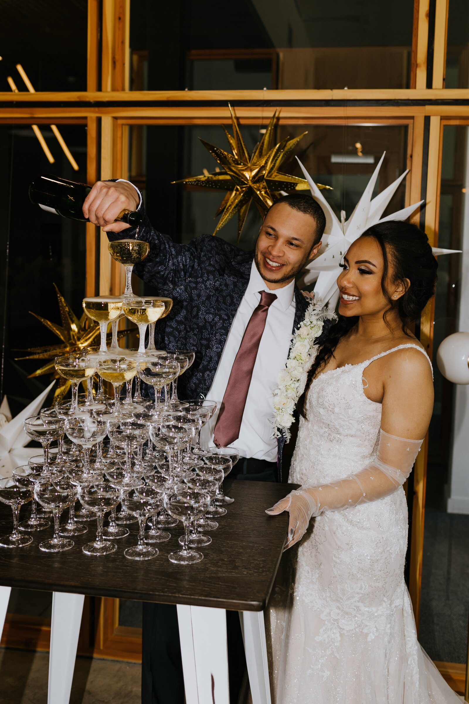 Couple pours onto a champagne tower.