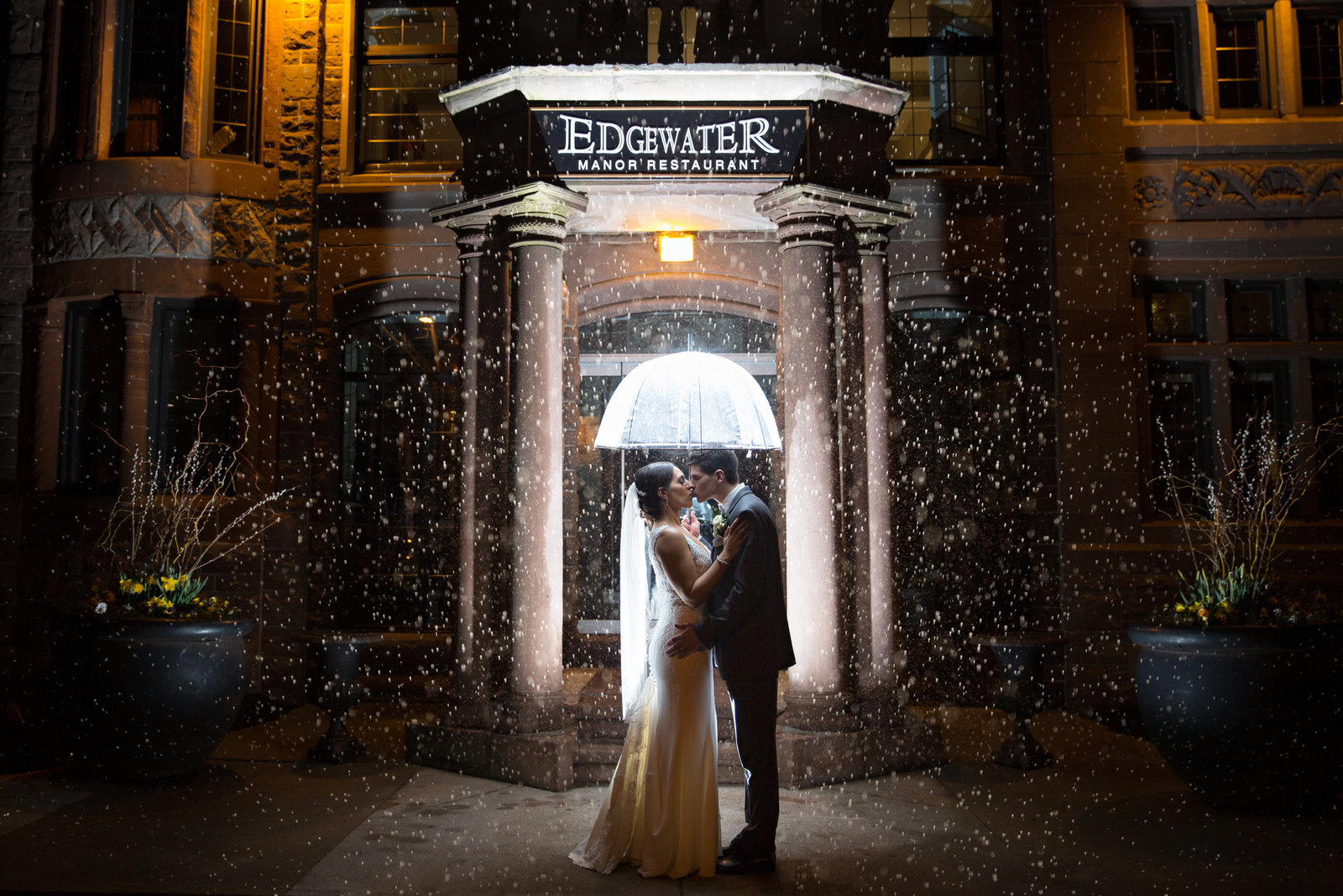 bride and groom at night in the rain with an umbrella
