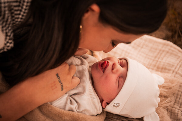 Een newborn fotoshoot in de natuur, omringt door de ouders en trouwe hond