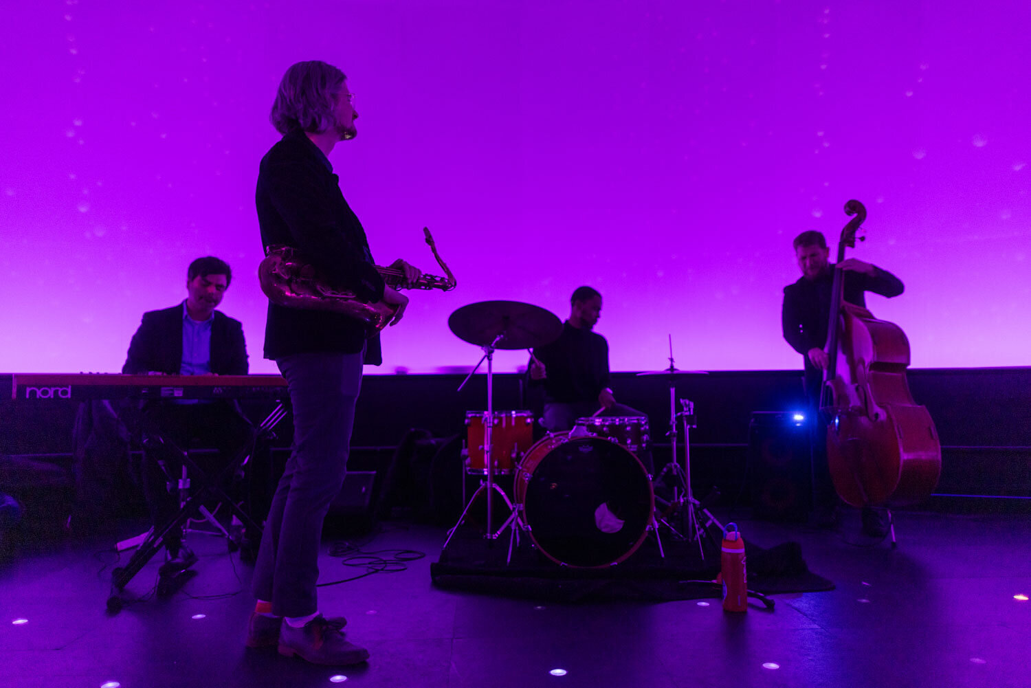 Jazz band performing on stage with purple lighting