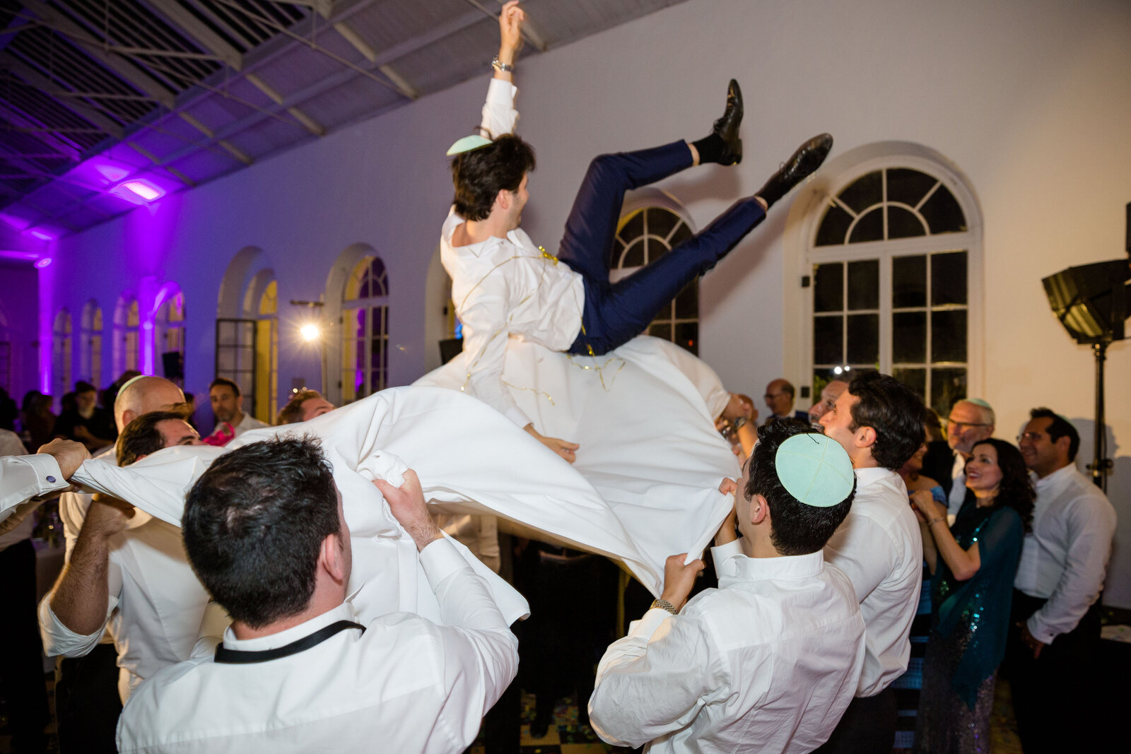 The Groom gets thrown in the air by guests