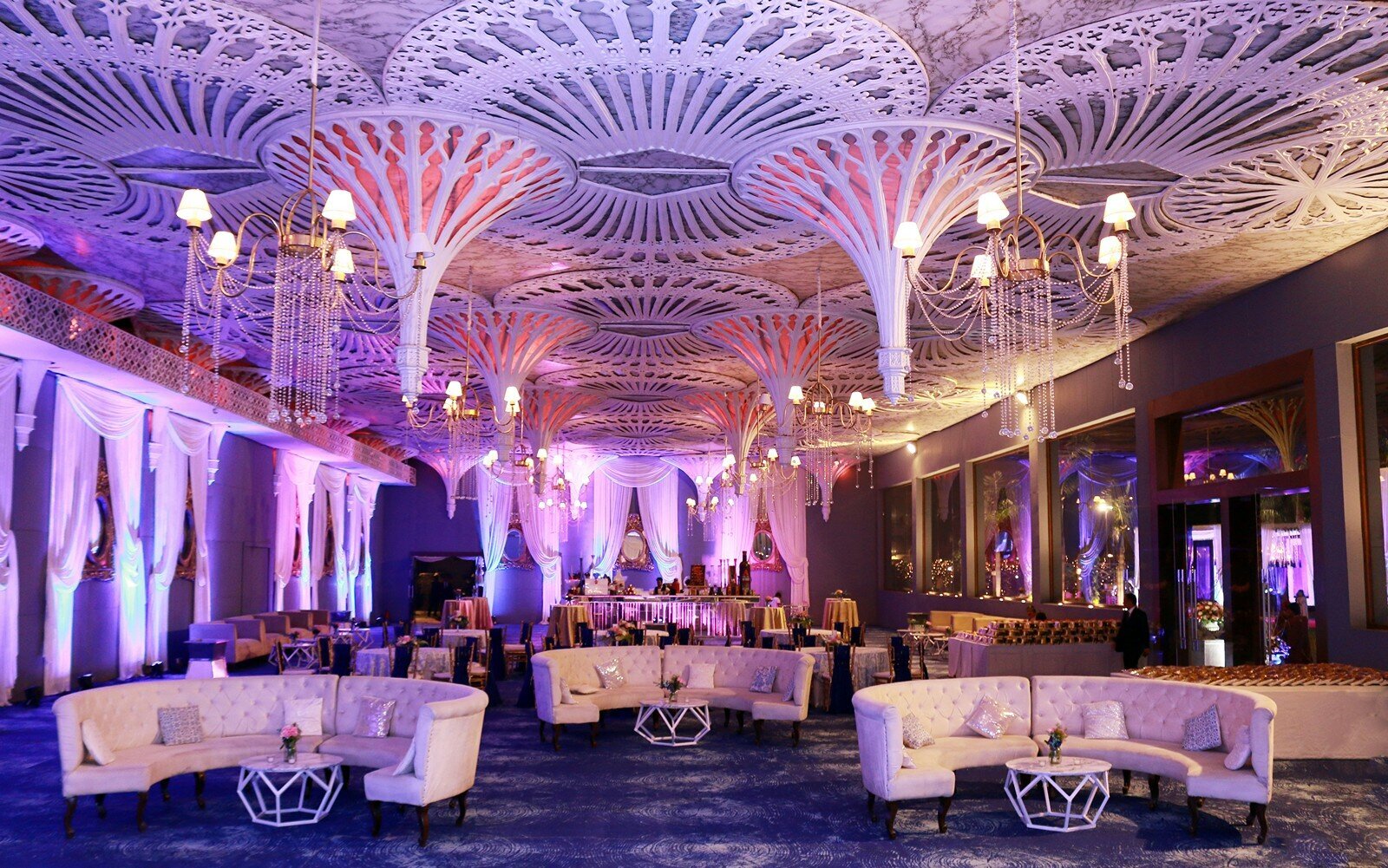 Lavish event space with dramatic ceiling décor and purple lighting
