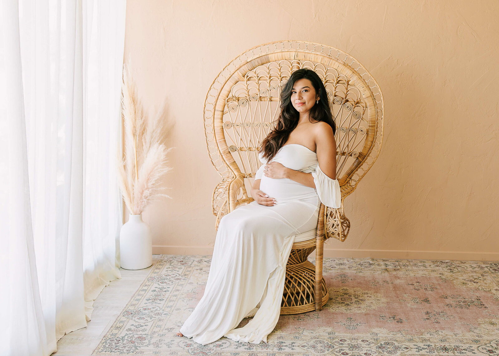 Expectant Mama posed in Peacock Chair in Studio by Ashley Nicole Photography.