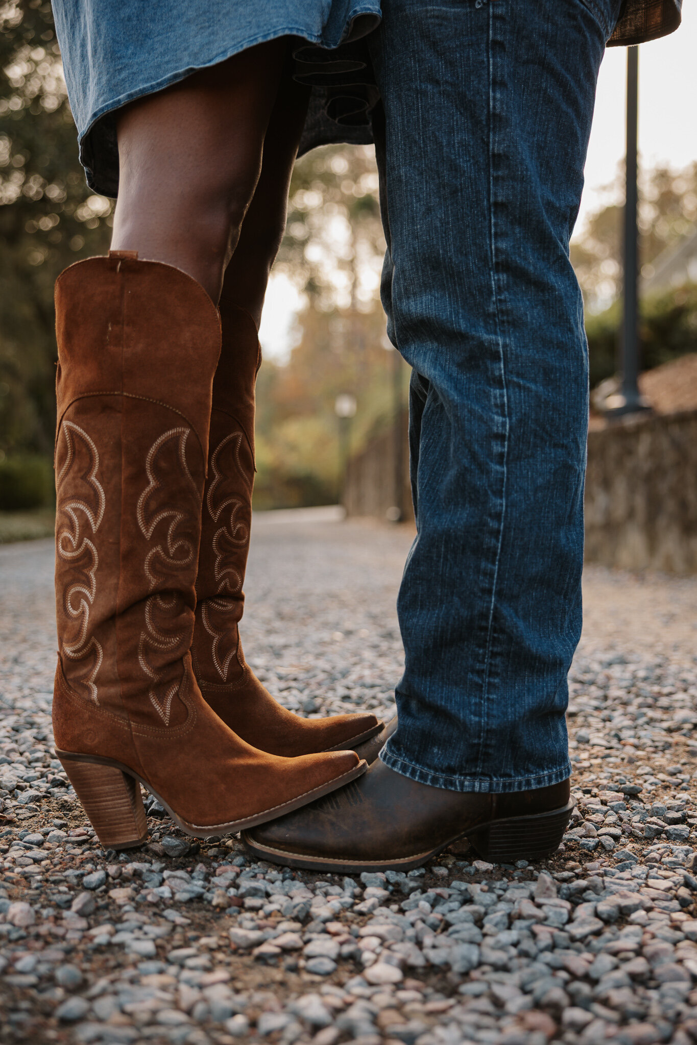 Close-up of a couple's cowboy boots and jeans during a couples session at Savannah Rapids in Evans GA.
