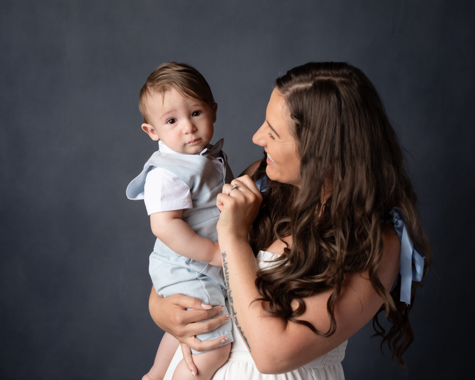 mom holding one year old boy for birrthday photoshoot