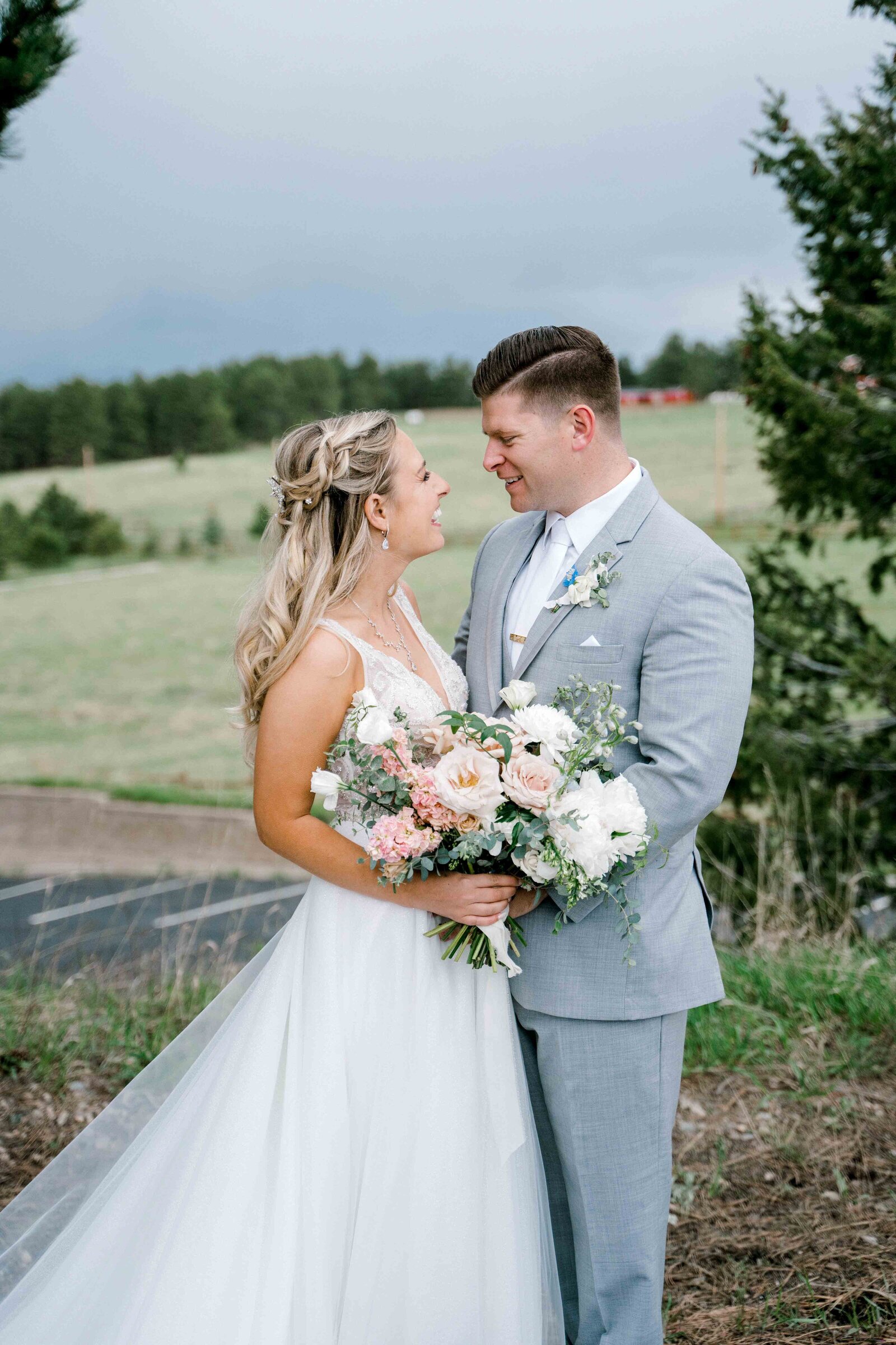 Bride and groom facing each other and holding the floral bouquet