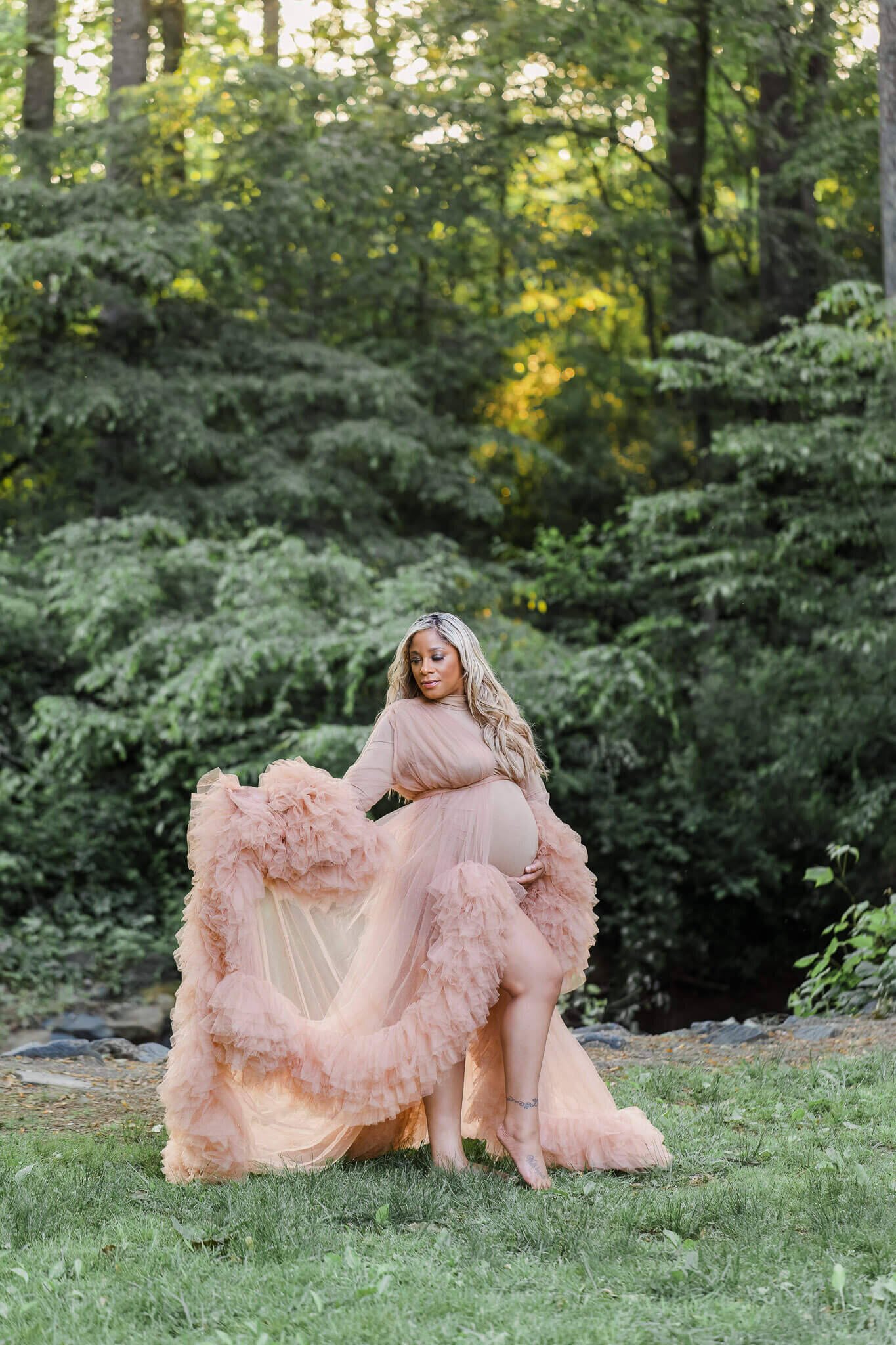 An expecting woman posing in a Centreville park at sunset.