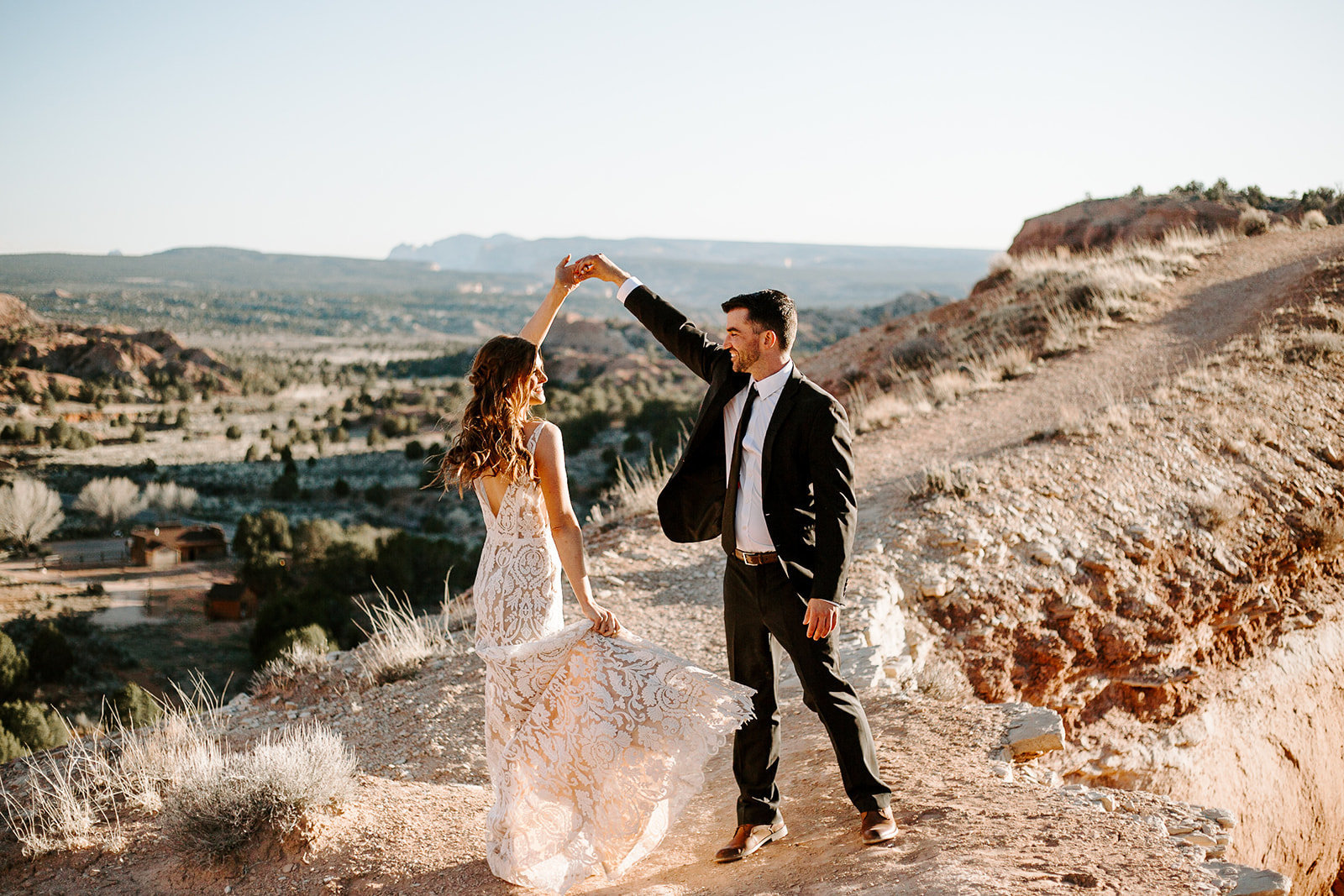 A couple dancing in the desert with their husband spinning the wife during their Arizona Elopement