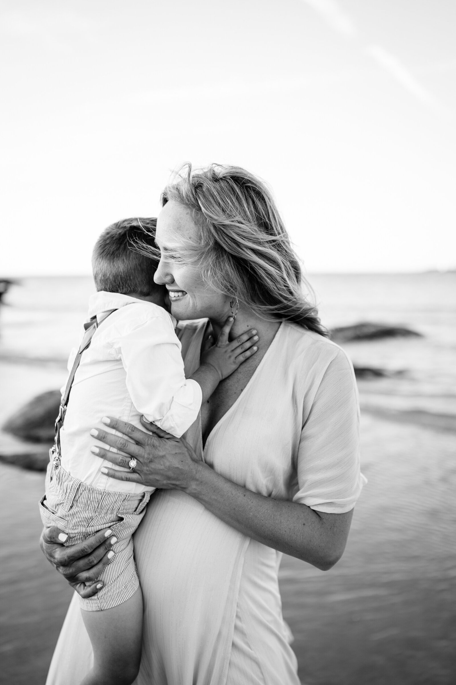 black and white portrait of mother hugging toddler son during family photos