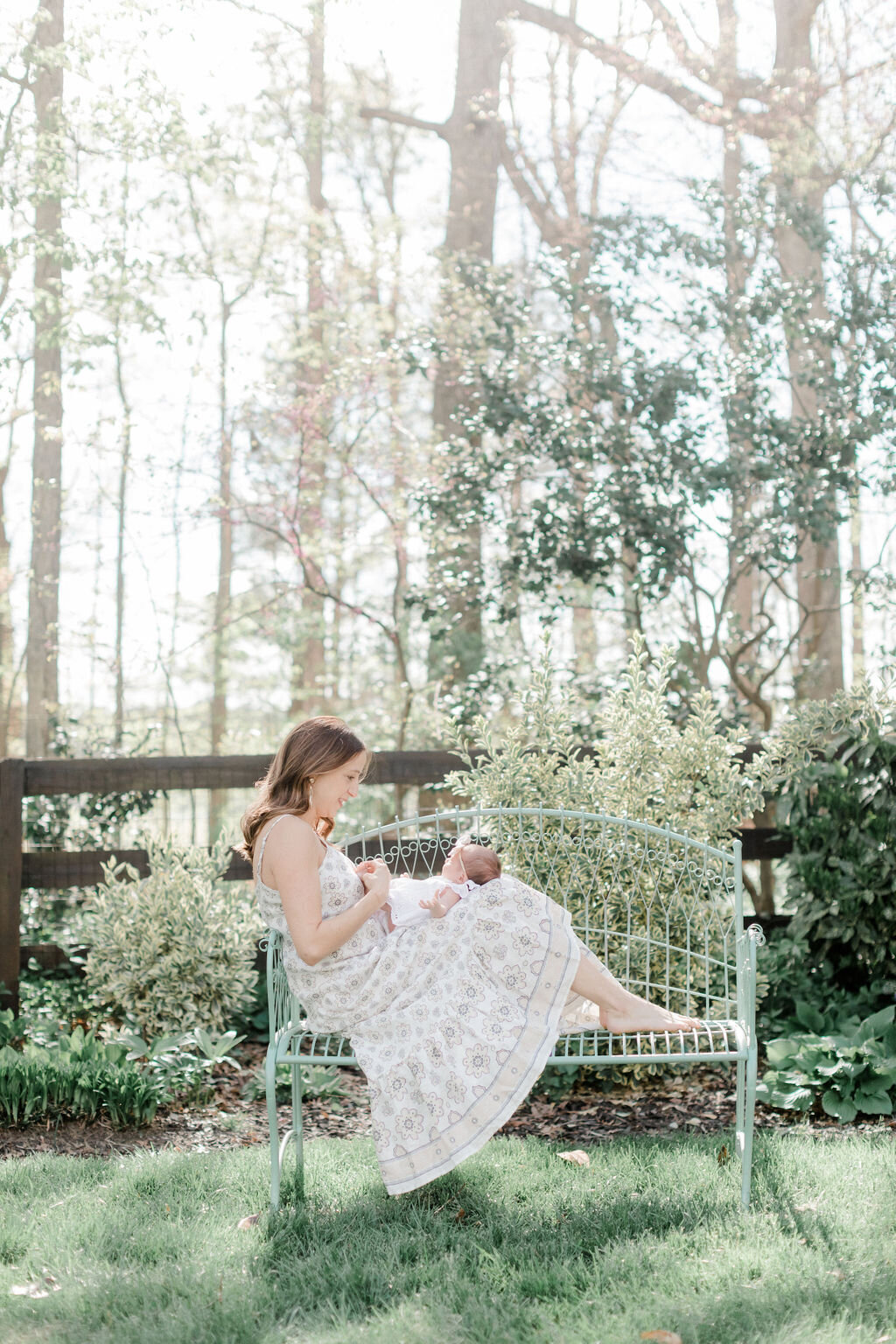 A mother looking tenderly at her newborn daughter during a lifestyle newborn session in Richmond, Virginia. This newborn session was done both indoors and outdoors to capture the true environment of the family.