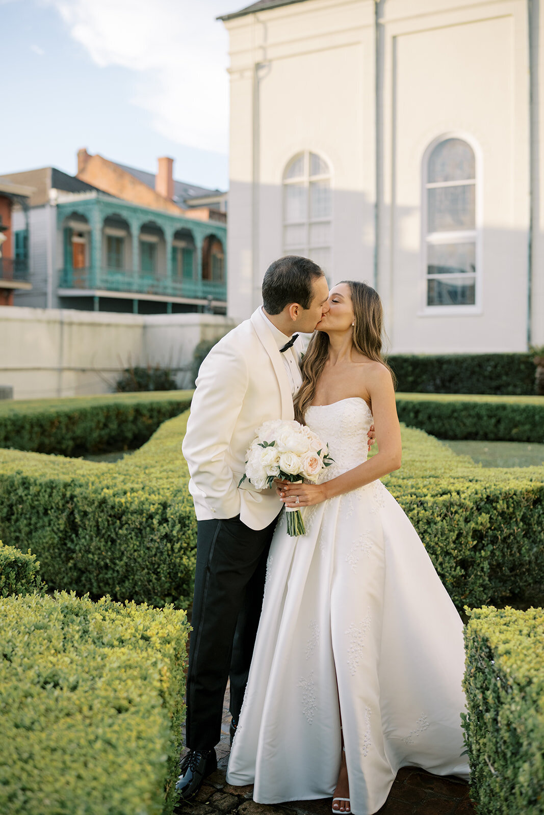 bride and groom kissing in hedges