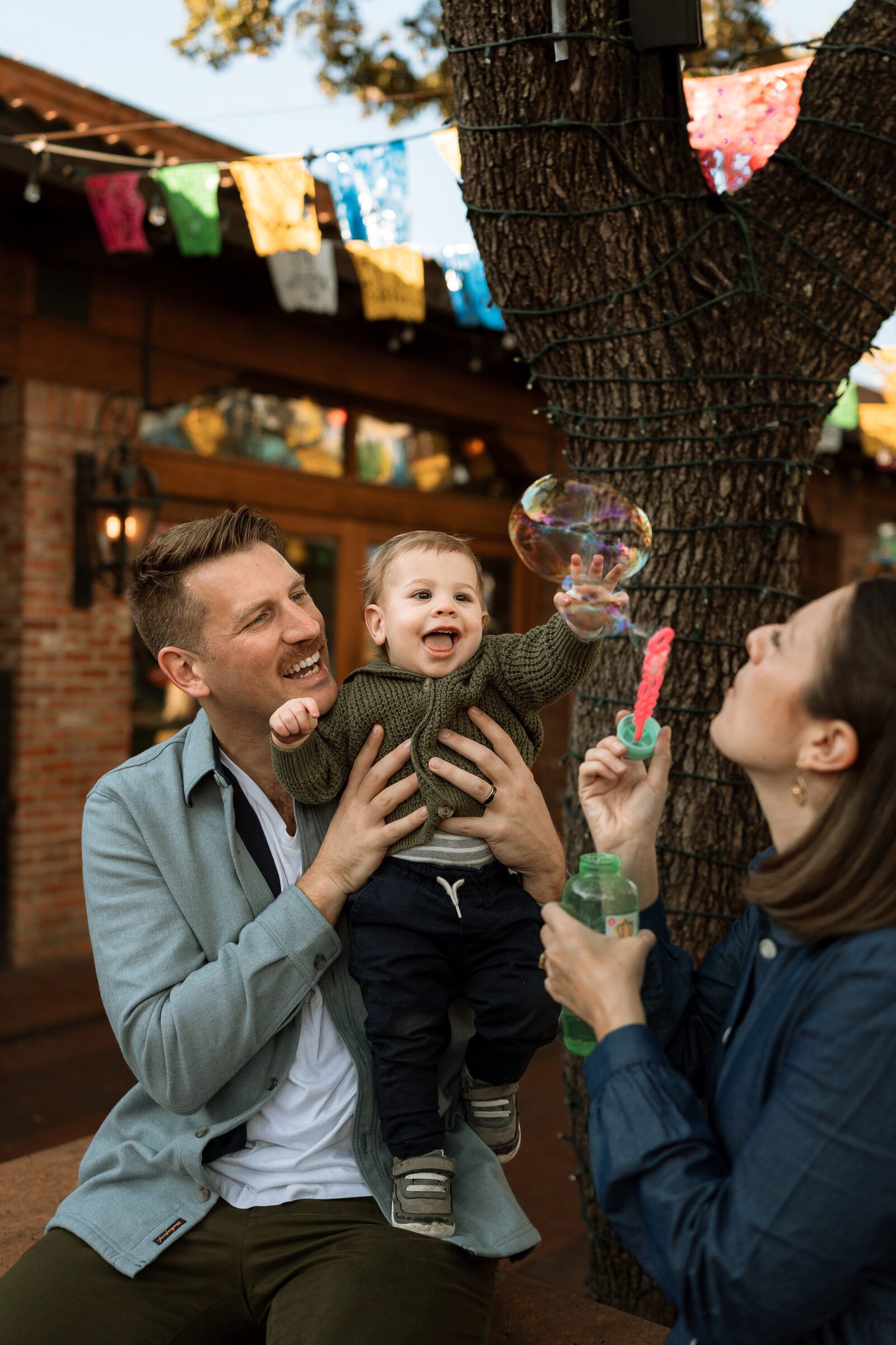 mom blowing bubbles for baby boy