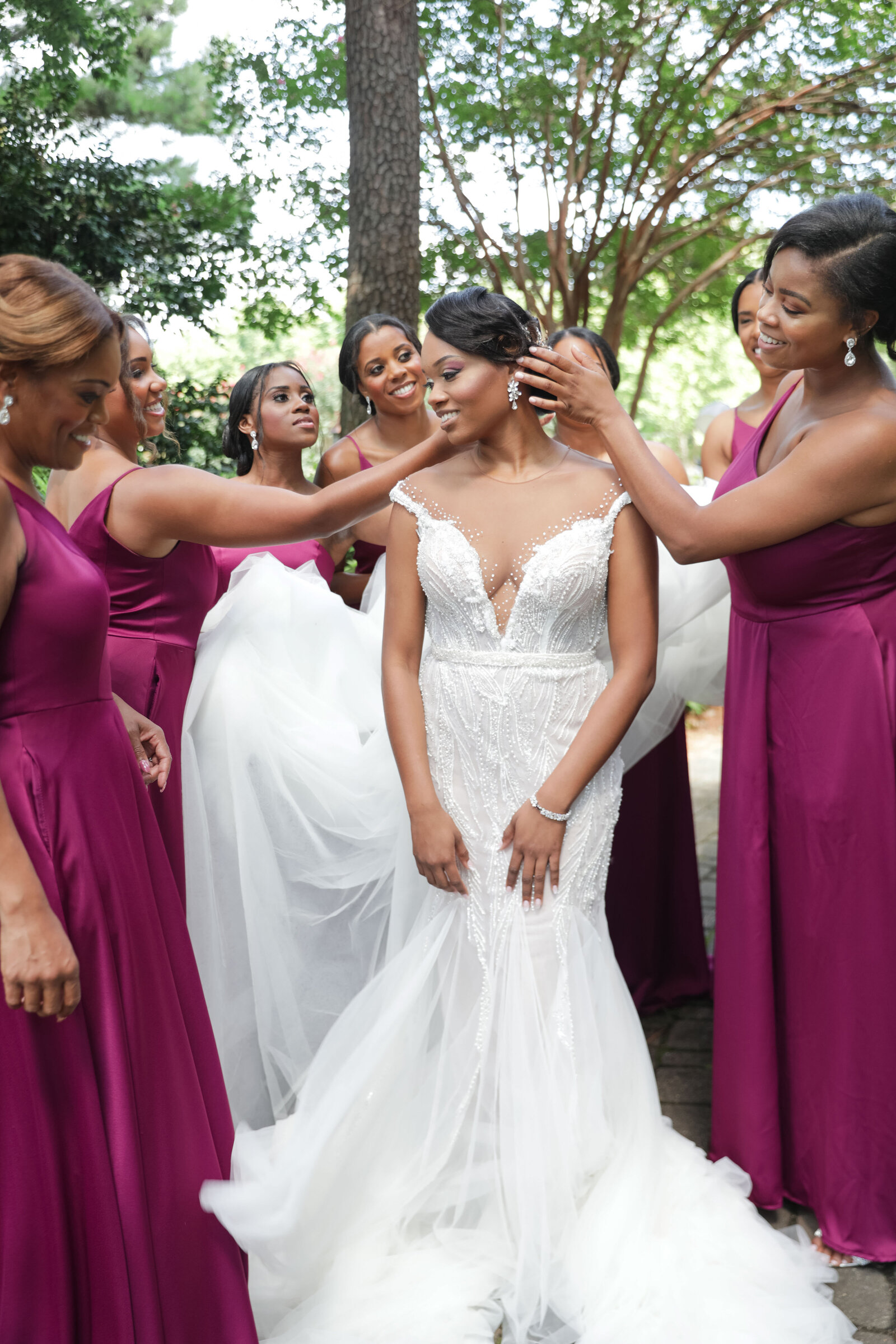 Bridesmaids assisting the bride with her gown in a heartwarming pre-ceremony moment.