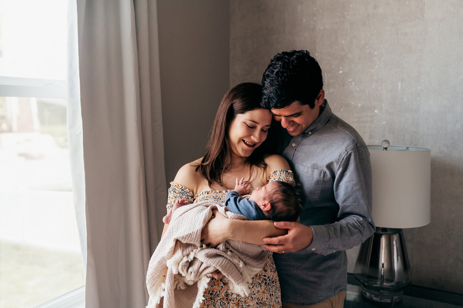 couple holding new baby in their home