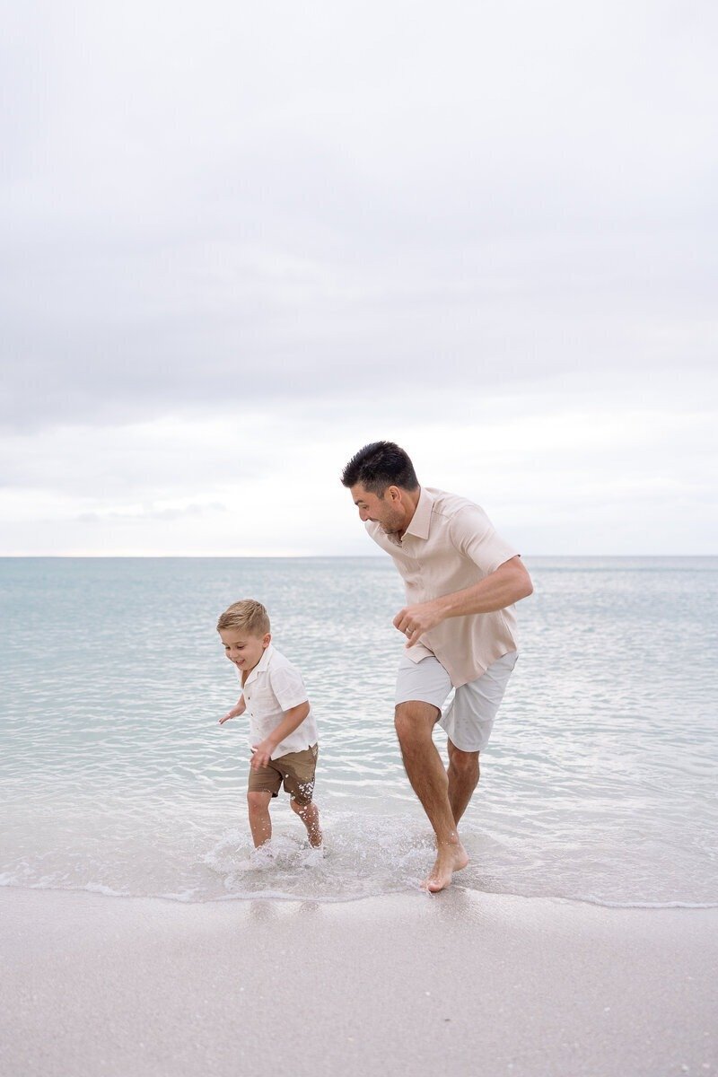 dad with son running on beach, taken by naples fl family photographer