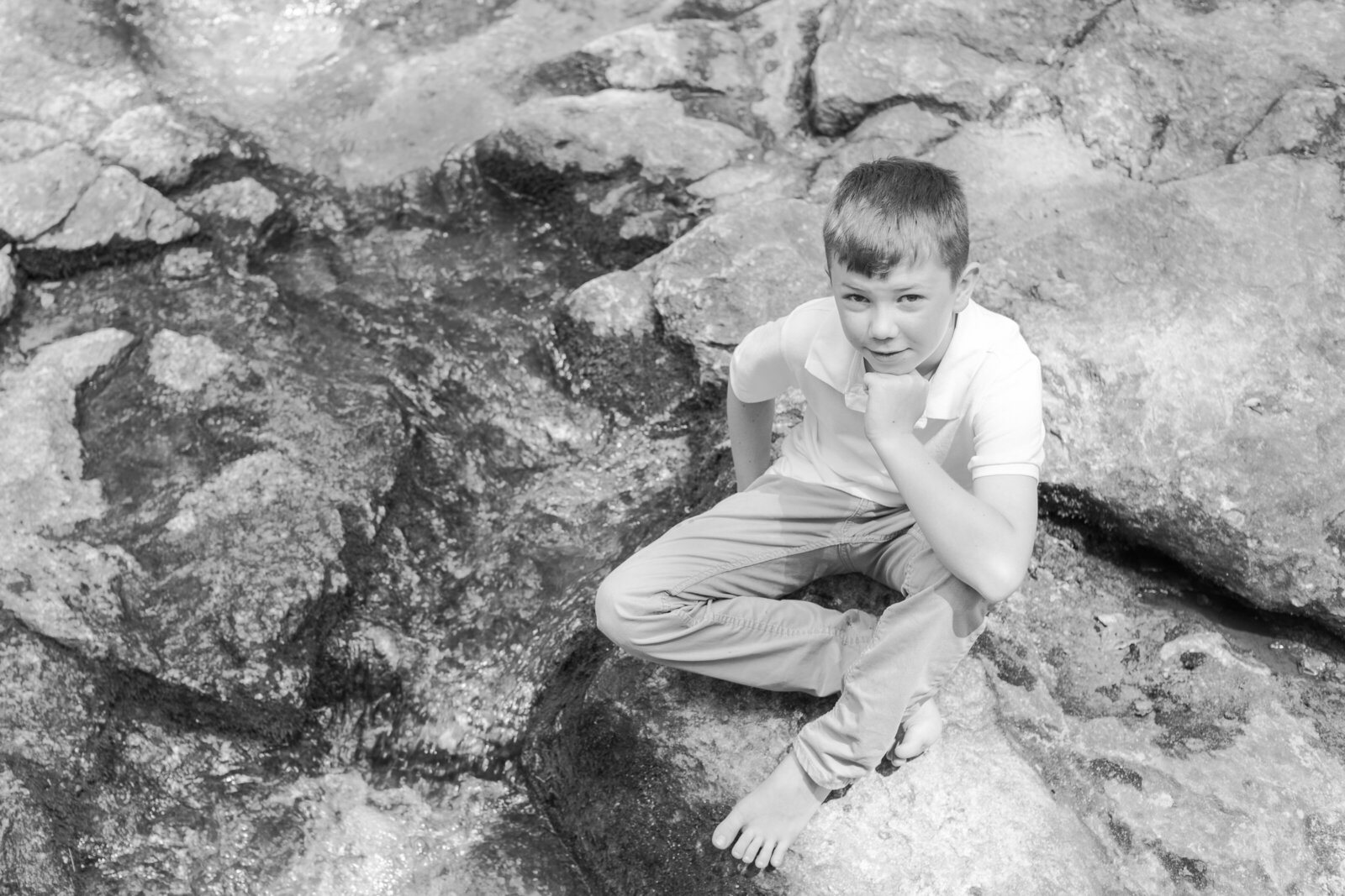 preteen boy on rocks near stream in Kernersville NC