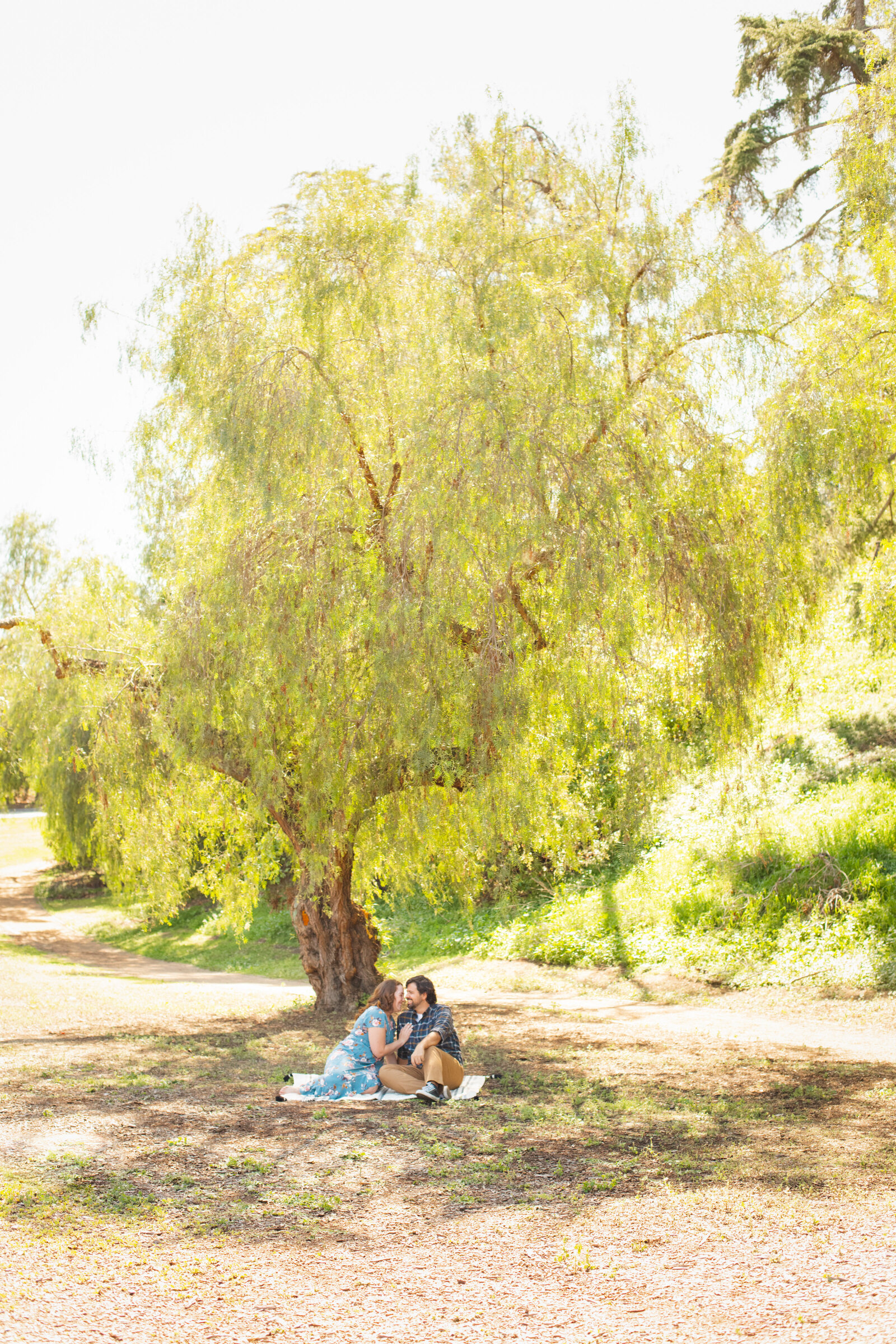 An engaged couple poses for photos in a garden in Los Angeles, Ca.