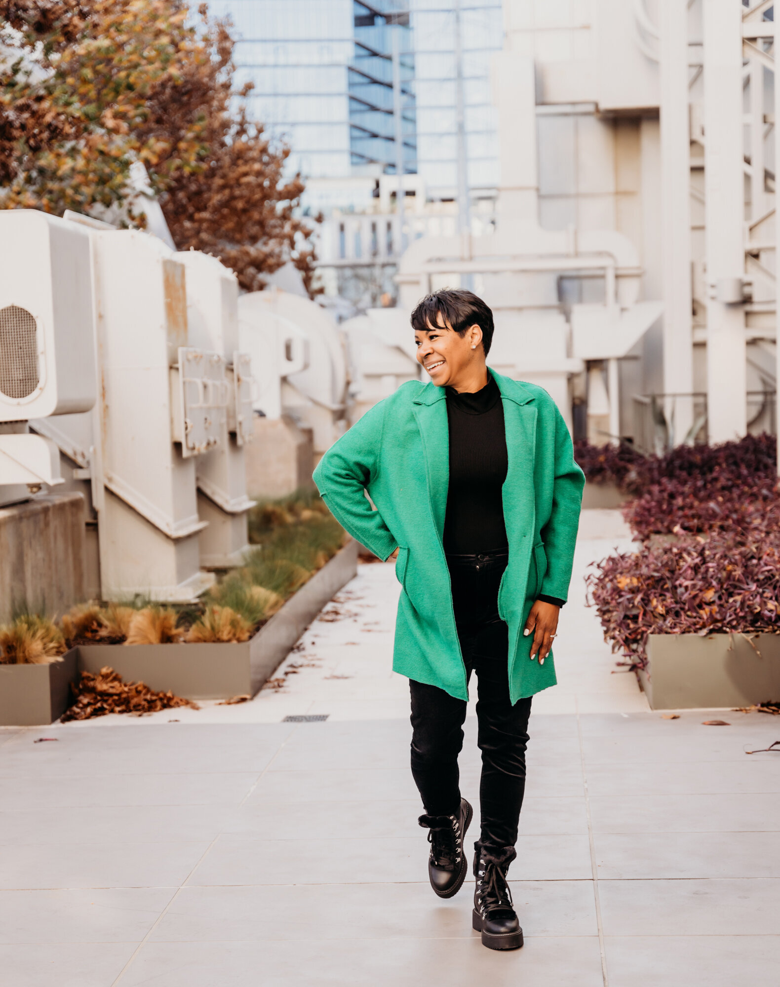 Branding Photographer, a woman wears a jacket, jeans, a nd boots and walks near an industrial part of town