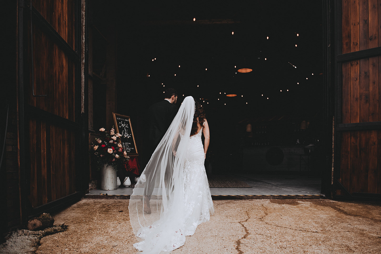 Bride and groom walking into their wedding reception at Manor Barn in Cambridge