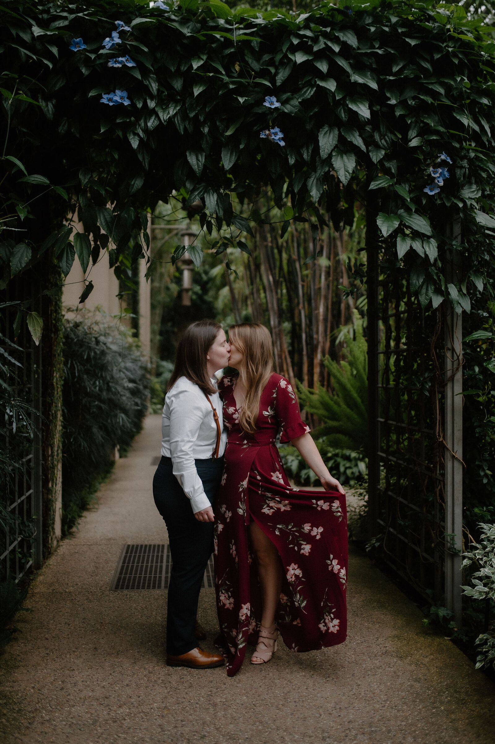 couple kissing under green archway at Longwood Gardens