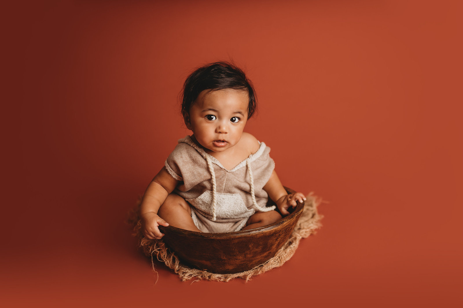 6 month old boy sitting in bowl prop during milestone photo session in Tampa Bay