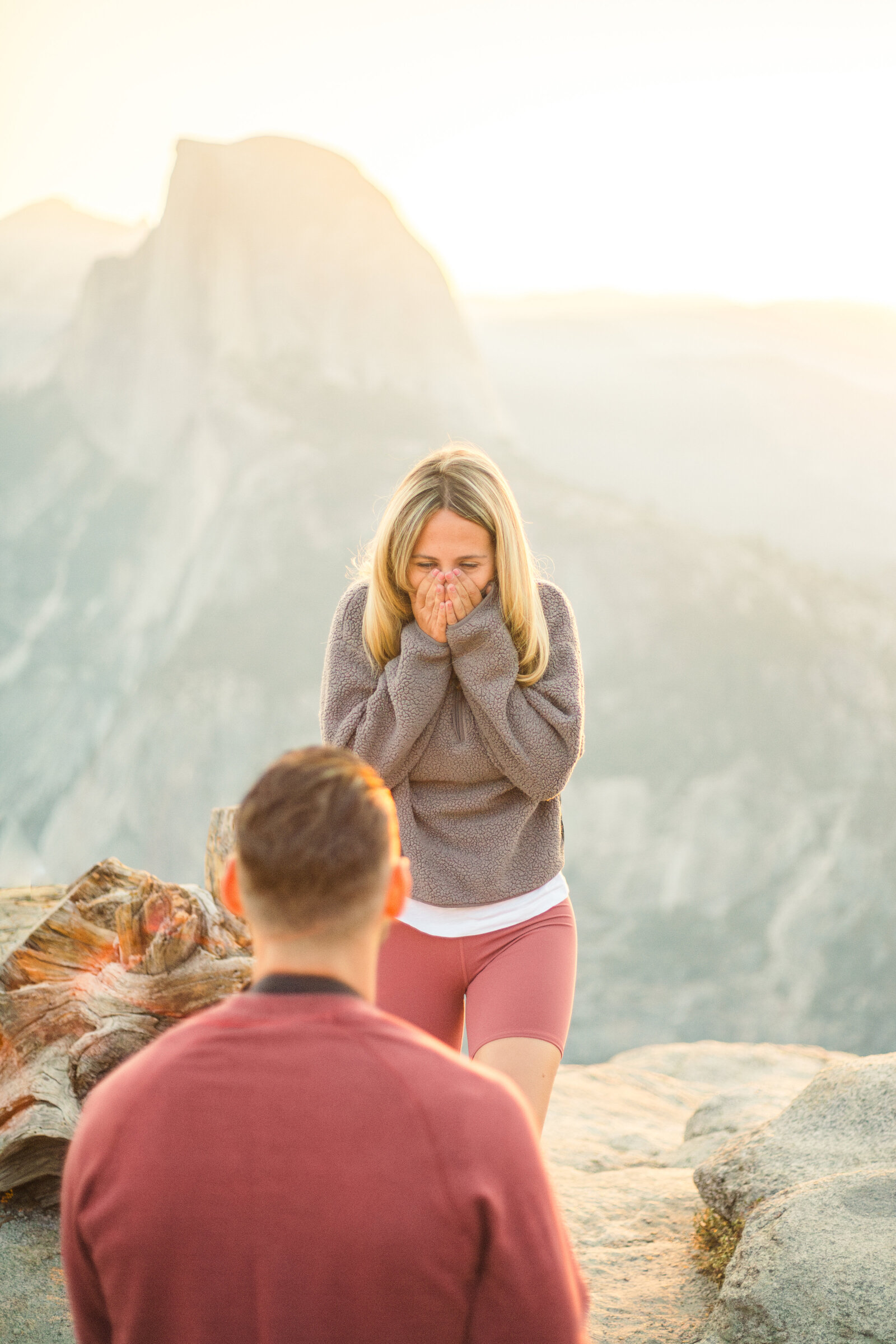 A wedding proposal between two hikers at sunrise in front of Half Dome in Yosemite National Park.